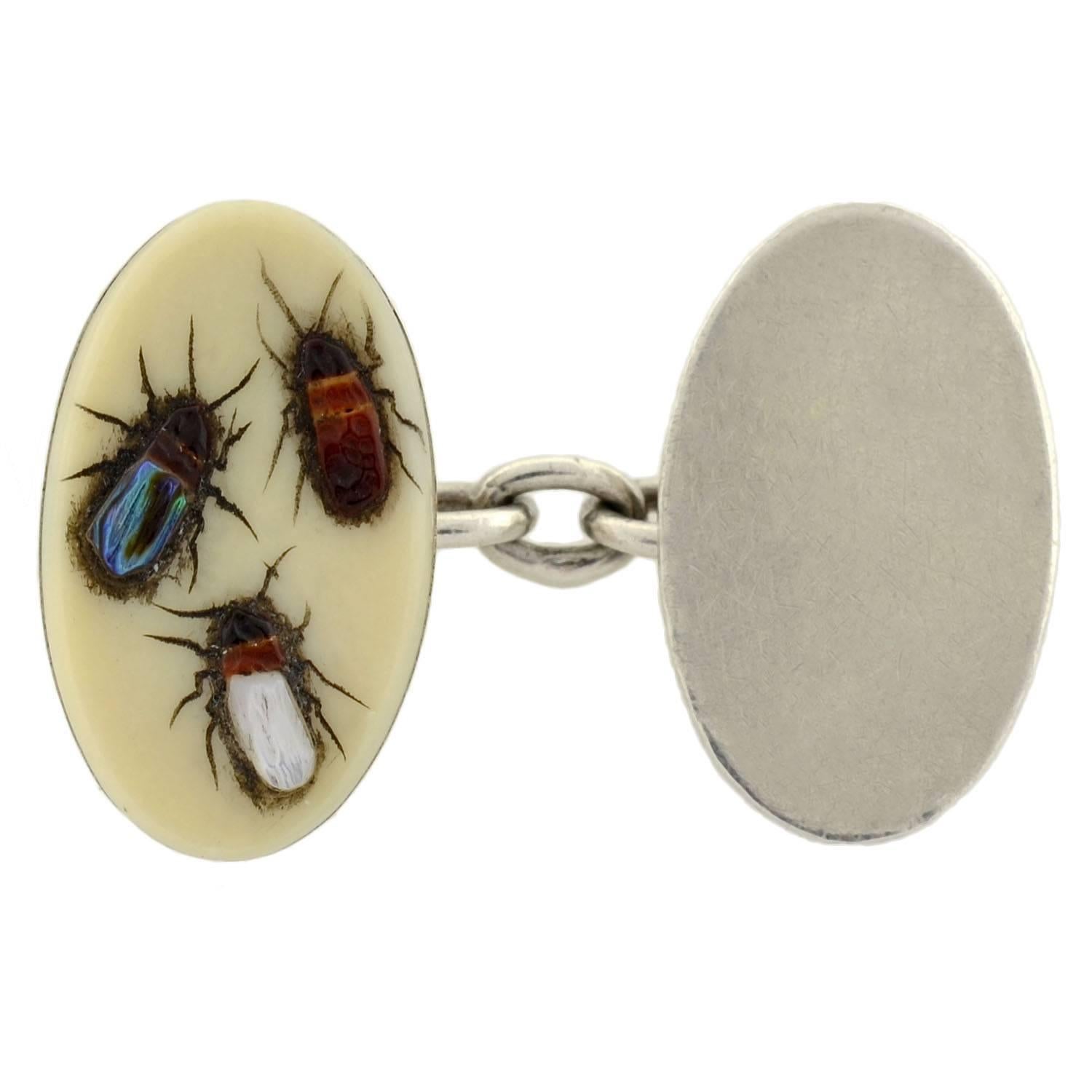 A wonderful and unusual pair of cufflinks from the Victorian era (ca1880)! Made of silver, the double-sided cufflinks have a colorful insect motif inlaid into a smooth bone background. The insects' legs and antennae are etched delicately into the
