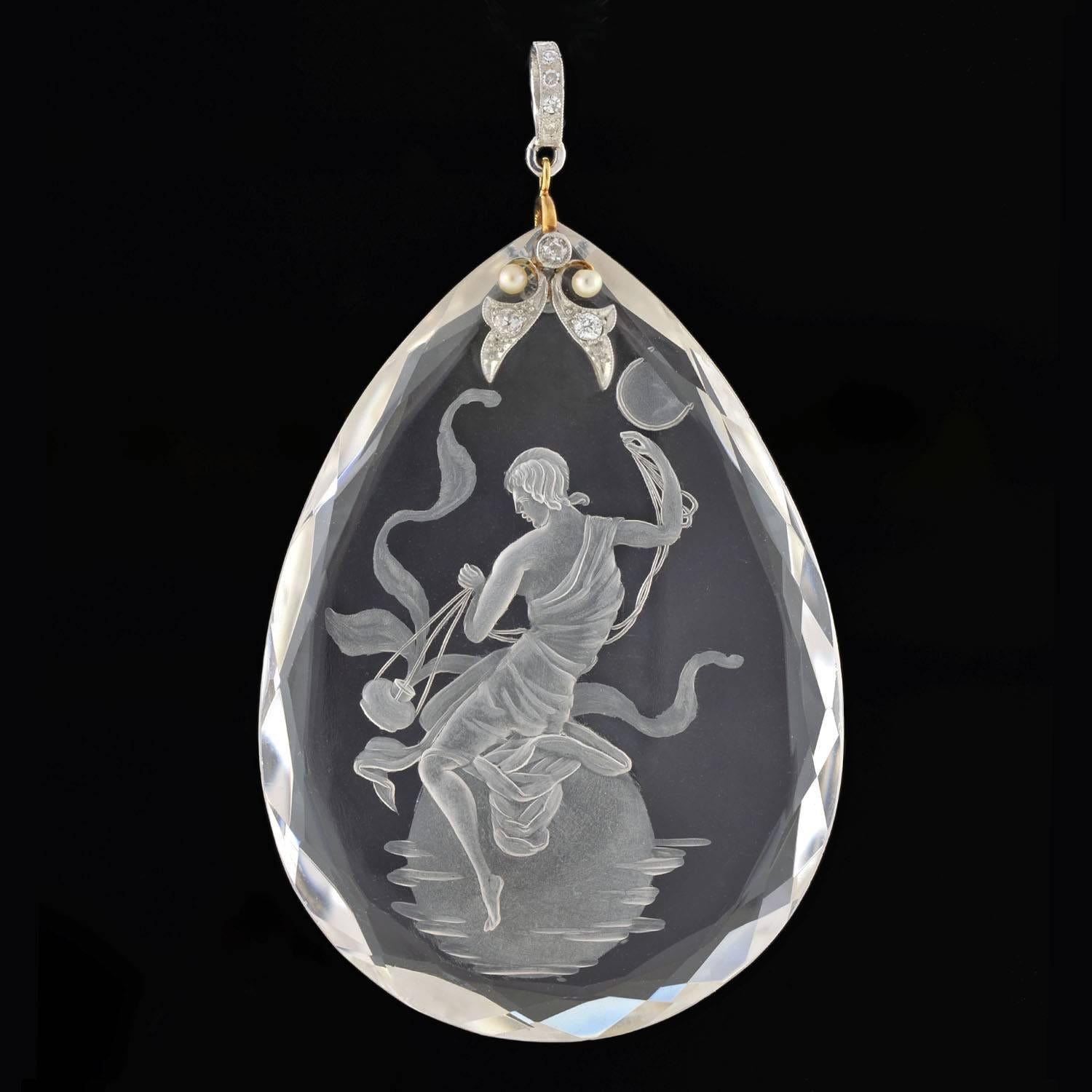 A gorgeous carved crystal pendant from the Art Deco (ca1920) era! This fabulous piece is comprised of a stunning teardrop shaped reverse carved rock crystal pendant which hangs from a diamond and pearl encrusted bail. The carved image is of a robed