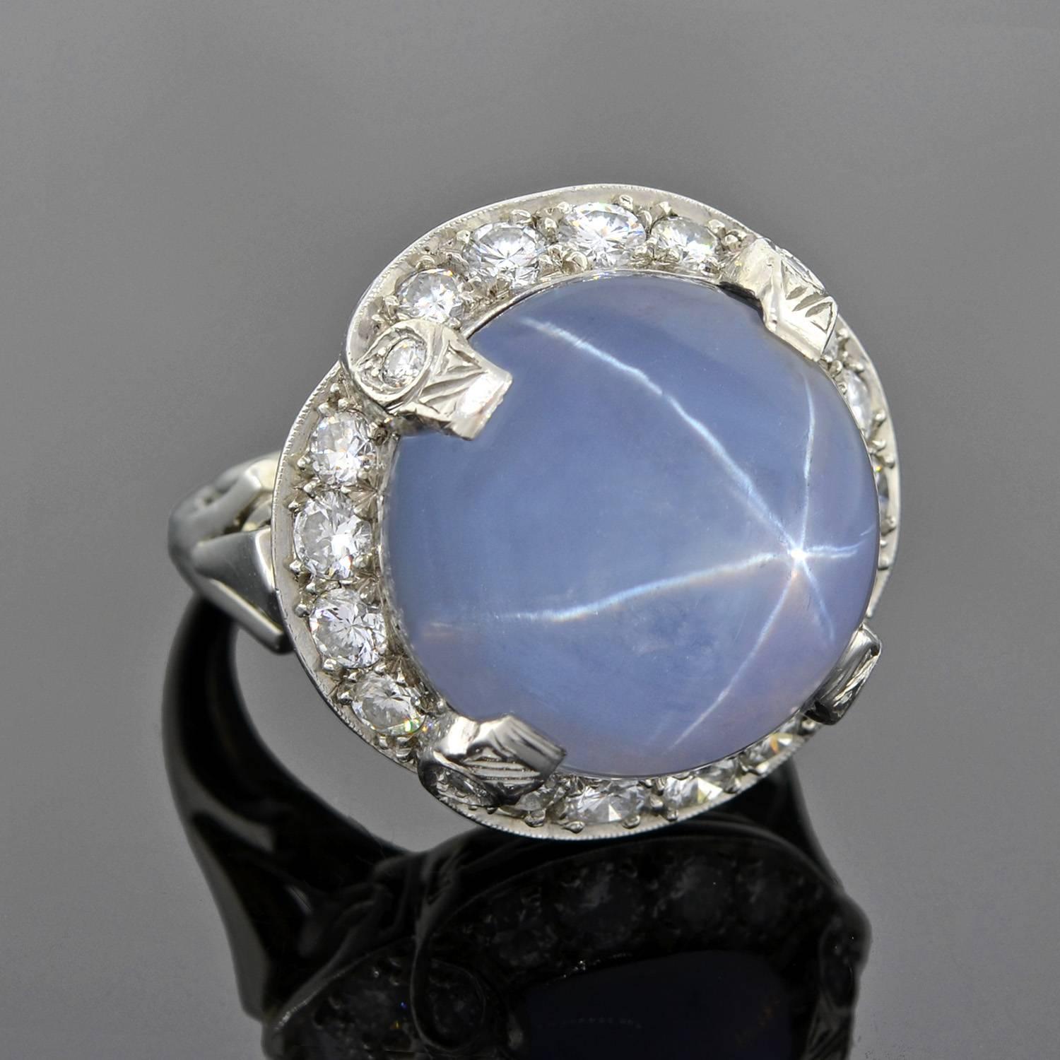 A simply stunning sapphire and diamond cocktail ring from the Late Art Deco (ca1935) era! This fantastic piece has a large, natural star sapphire center that is a round cabochon shape. The stone weighs approximately 12ct+ and has a wonderful, rich