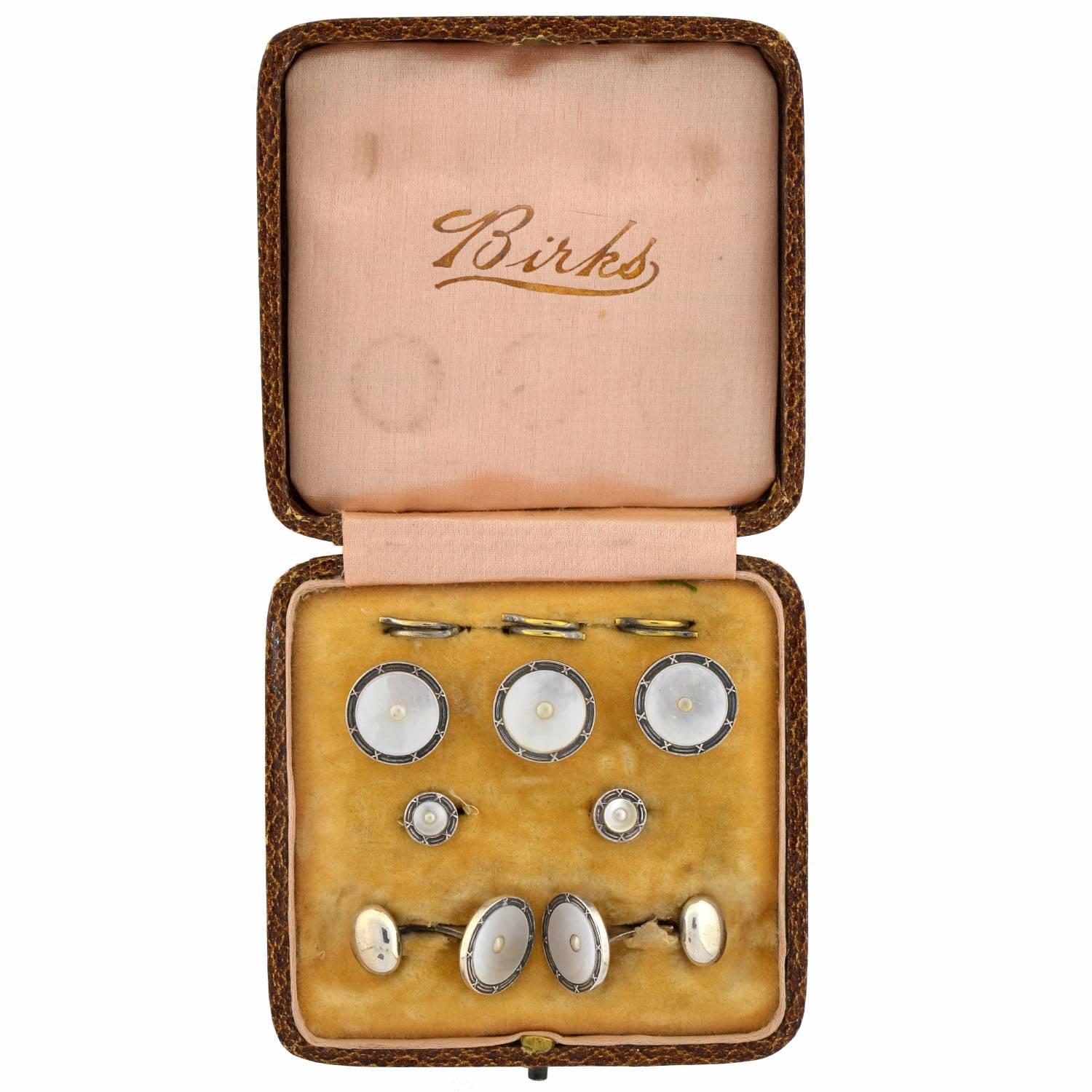 A lovely Birks cufflink set from the Art Deco (ca1920) era! This boxed set includes a pair of cufflinks, two shirt studs, and three matching buttons with connecting loops.  Each piece is crafted in sterling silver and has design that combines