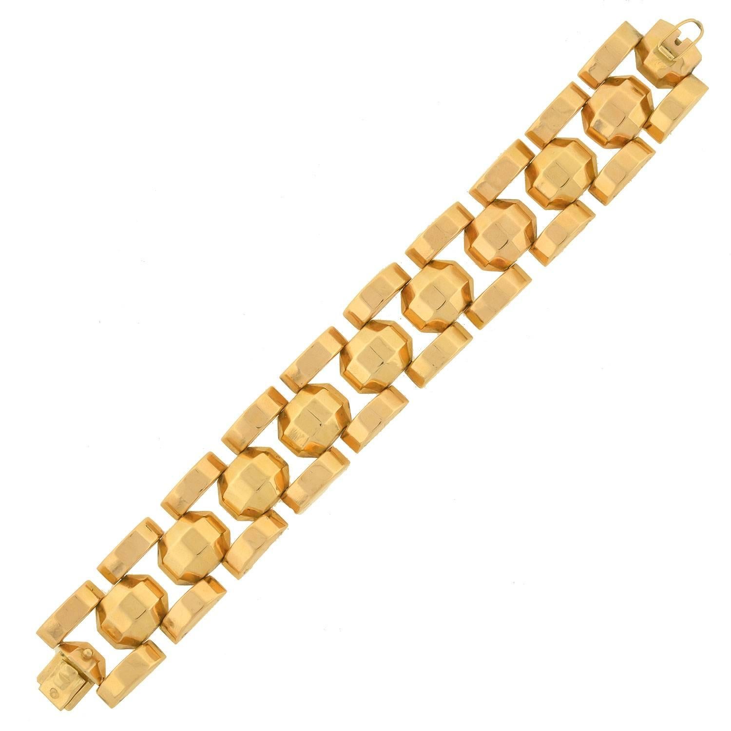 A fabulous gold tire track link bracelet from the Retro (ca1940) era! This hefty, bold looking piece is made of 18kt yellow gold and is French in origin. The design is comprised of 3 rows of links which have a faceted surface that catches the light