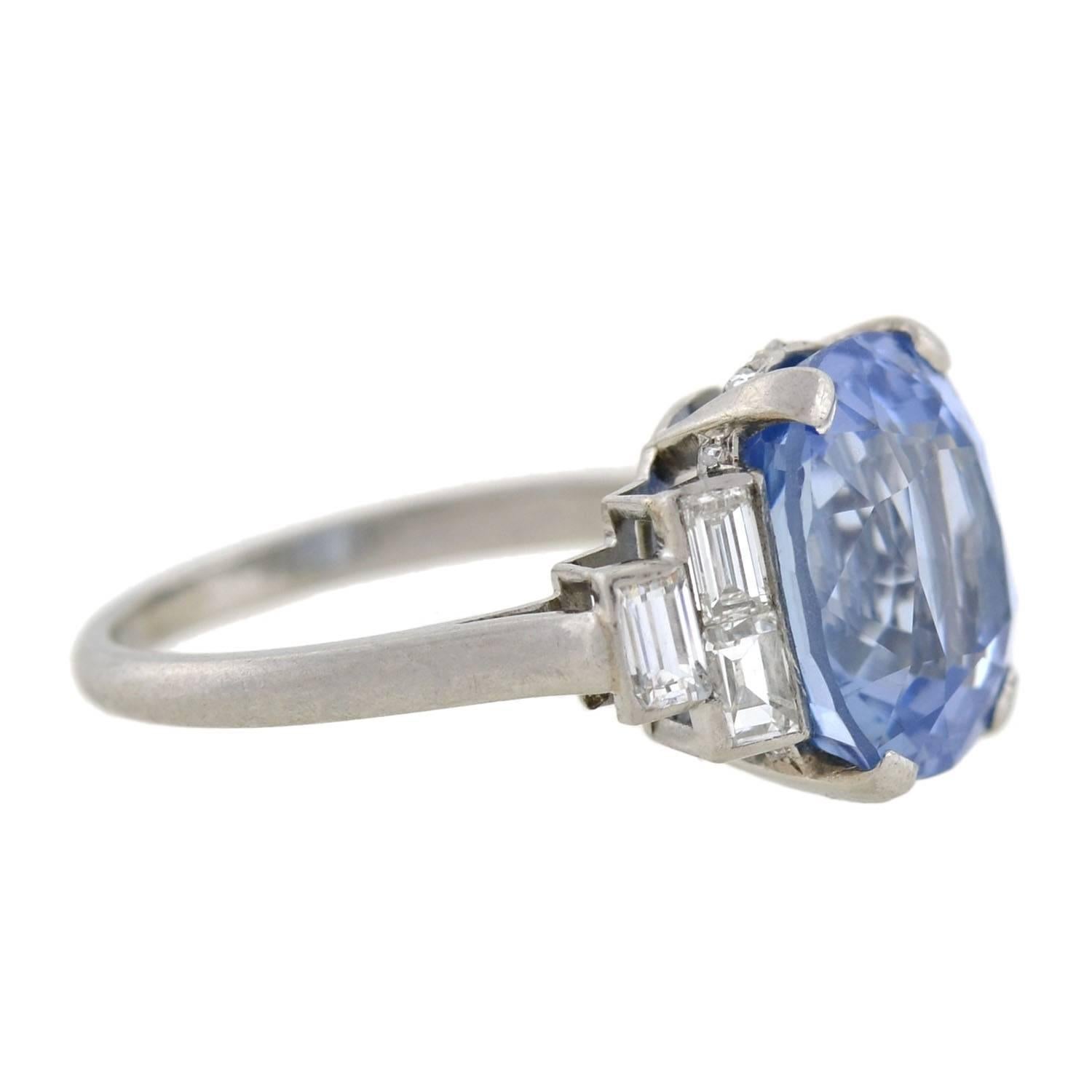 A stunning sapphire and diamond ring from the late Art Deco (ca1930) era! Made of platinum, this exquisite ring holds a cushion cut sapphire at the center, framed by baguette diamonds at either shoulder. The sapphire weighs 7.11ct and has a gorgeous