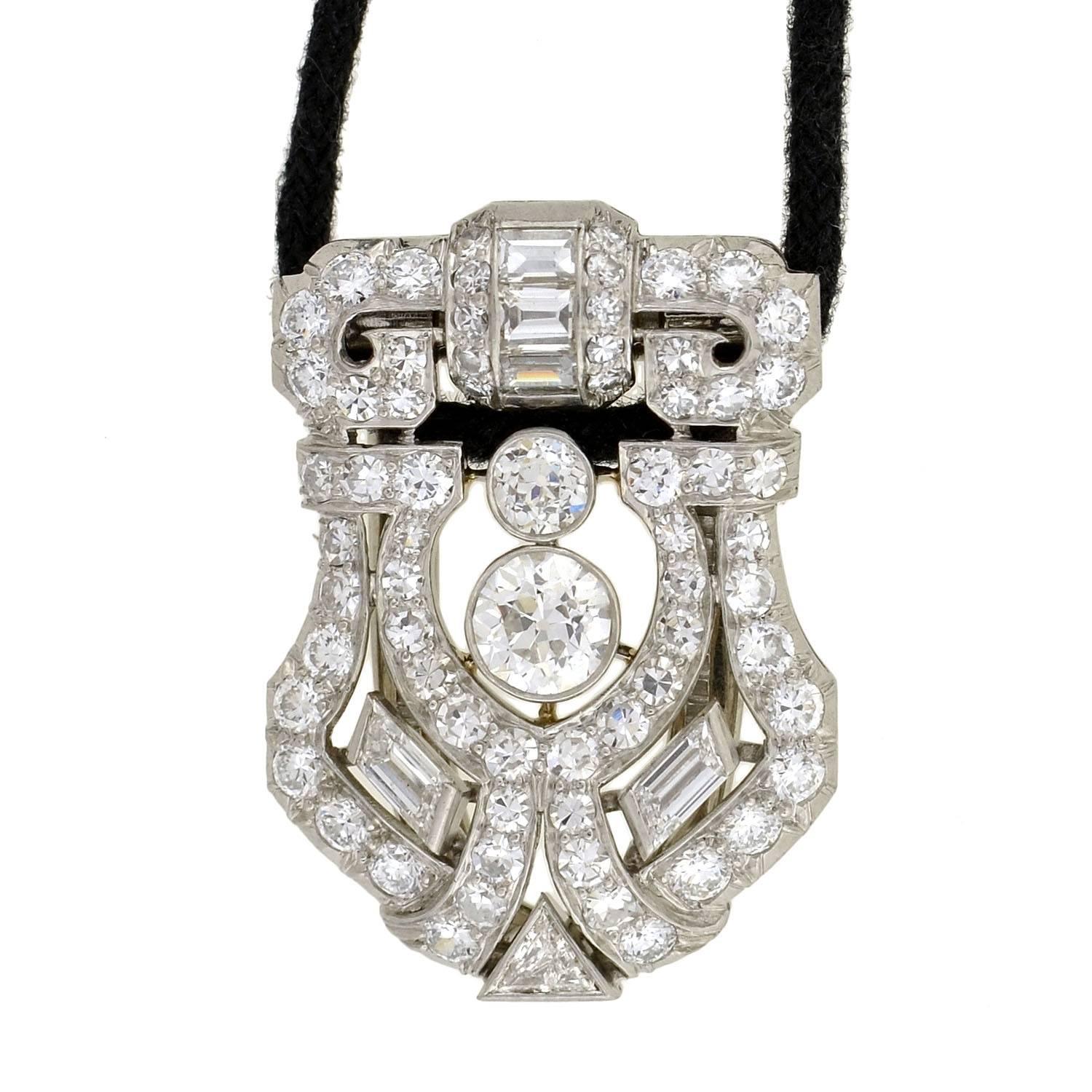 A magnificent platinum and diamond clip pendant necklace from the Art Deco (ca1920) era! This exceptional piece is comprised of a shield shaped clip pendant that is encrusted with sparkling diamonds. The pendant is made of platinum and has over