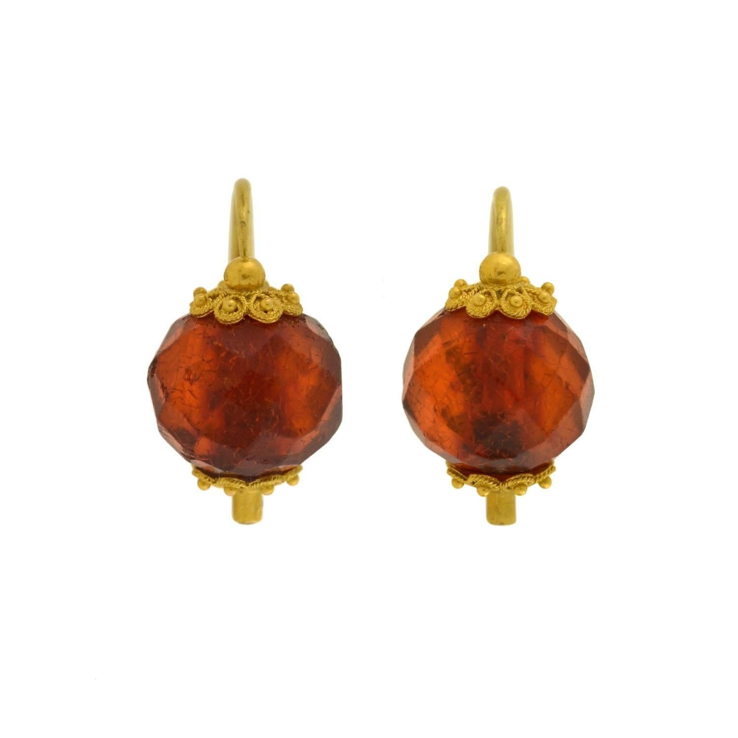 A gorgeous pair of amber earrings from the Victorian (ca1880) era! Each of these earrings has a convertible "day & night" design that incorporates a teardrop base and faceted bead topper. The 18kt yellow gold Etruscan setting combines