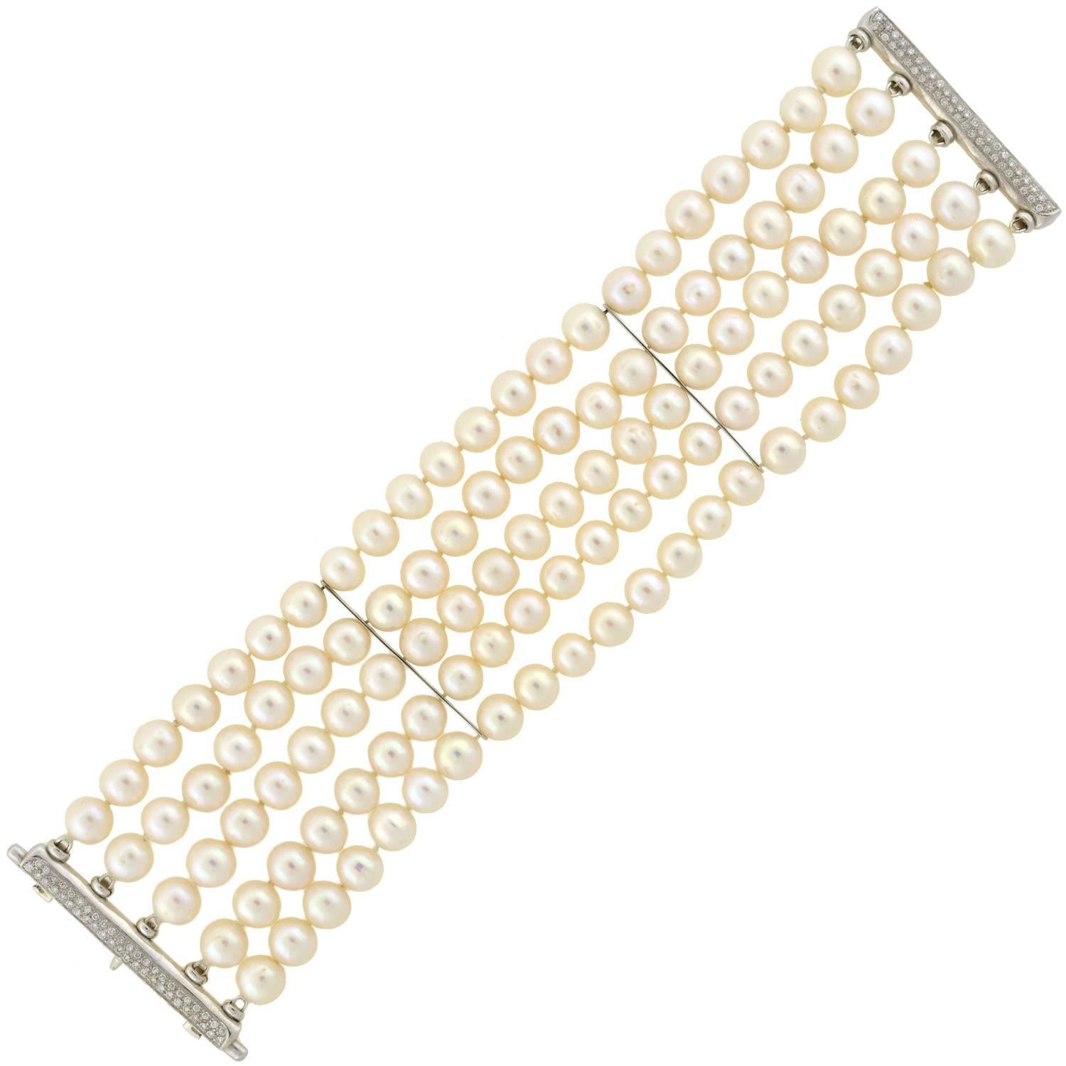 A gorgeous Estate pearl and diamond bracelet! This stunning piece is comprised of 5 strands of delicate cultured pearls, which have a rich creamy color and beautiful luster. Two 18kt white gold bar links separate the strands of pearls in the middle,