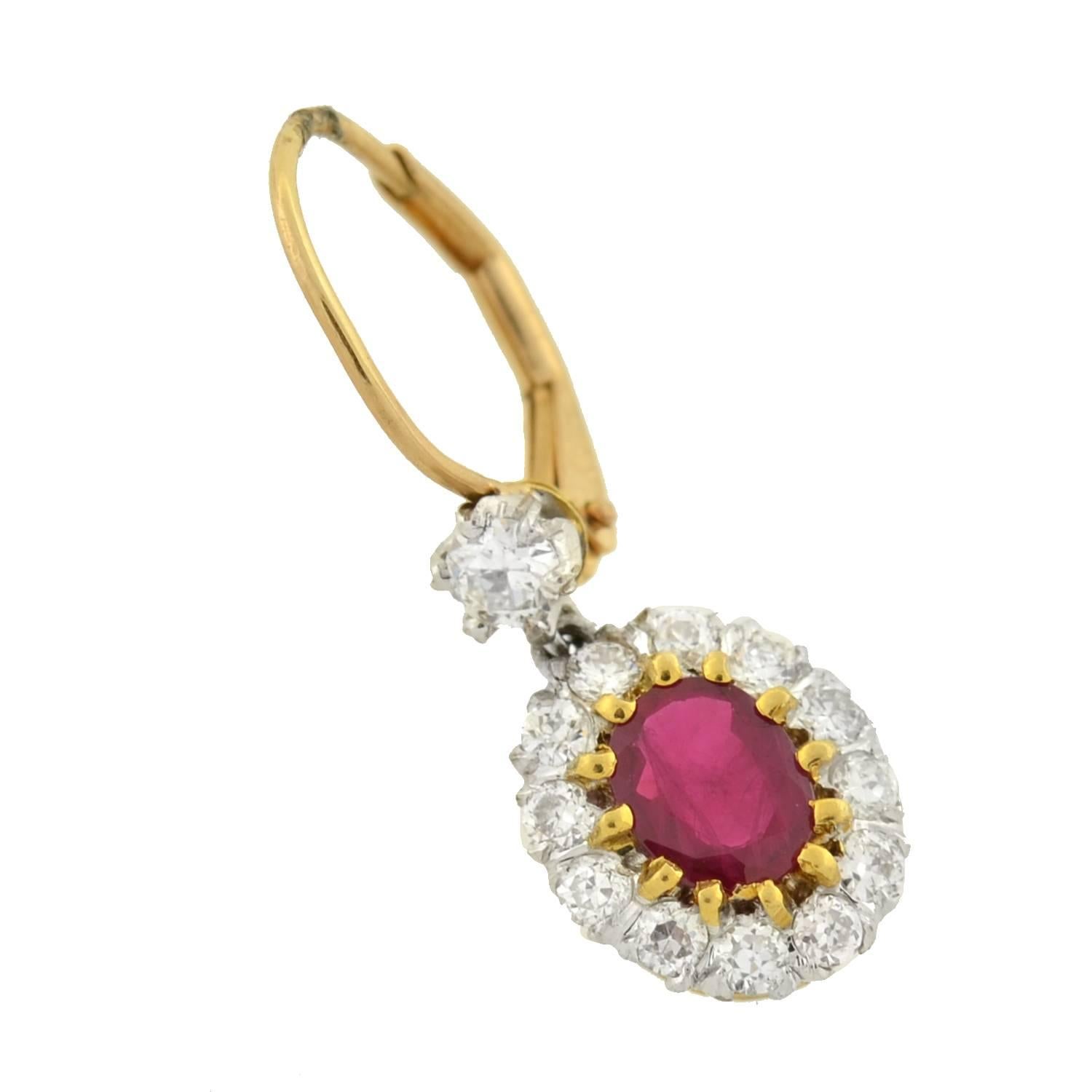 Absolutely exquisite contemporary ruby and diamond earrings! These gorgeous earrings are made of platinum topped 14kt yellow gold and each adorns a single, oval shaped ruby stone that rests in the center. The luscious, vibrant stones have a faceted
