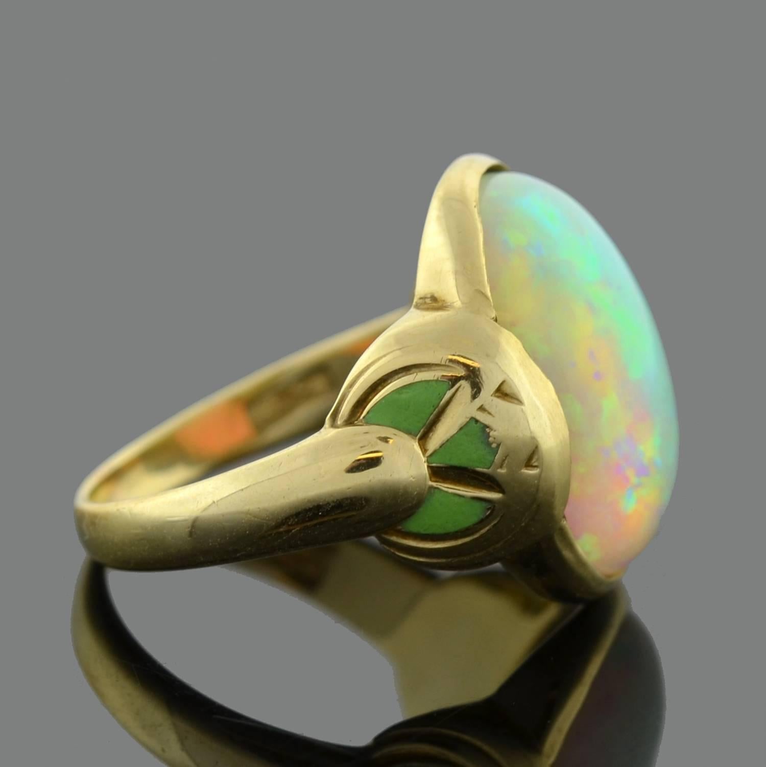 This marvelous opal ring is a signed piece by Larter & Sons from the Art Nouveau (ca1900) era! The alluring design features a large opal cabochon bezel set at the center a 14kt gold mounting. Each shoulder of the ring bears a decorative green