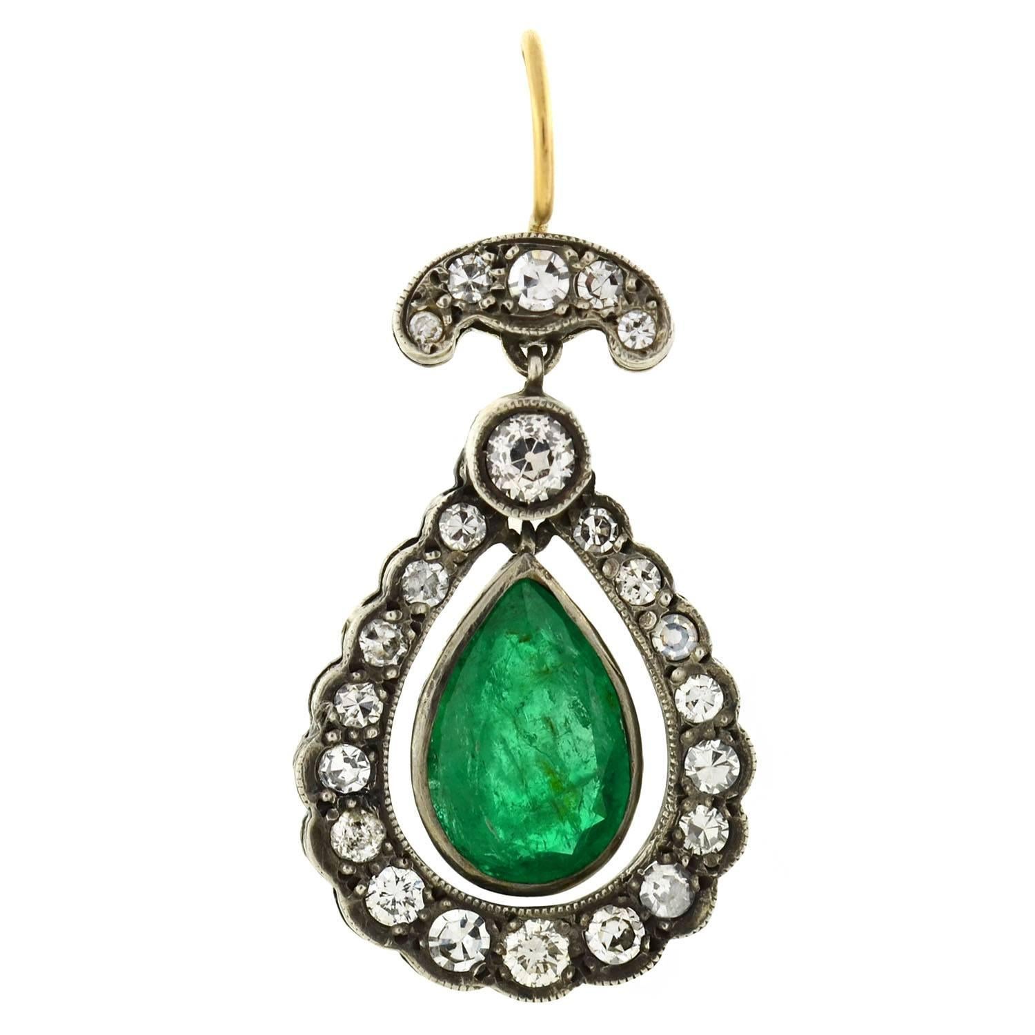 A spectacular pair of emerald and diamond earrings from the Edwardian (ca1910) era! These breathtaking earrings are crafted in silver and hang from 14K gold wires. Each earring frames a luscious emerald teardrop at the center of a sparkling diamond