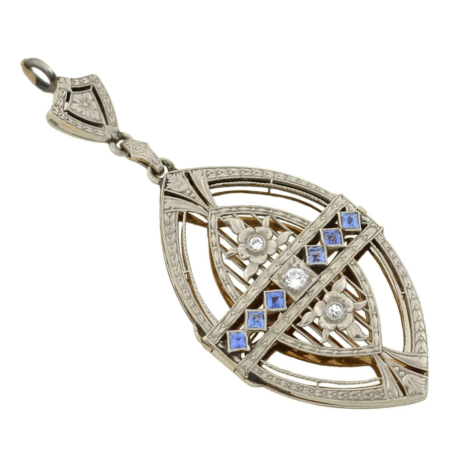 A unique and very unusual diamond and sapphire pendant from the Edwardian (ca1910) era! The pendant, which is made of platinum-topped 14kt yellow gold, has a shield-like shape and cage-like design. The entire piece is etched in a fabulous floral