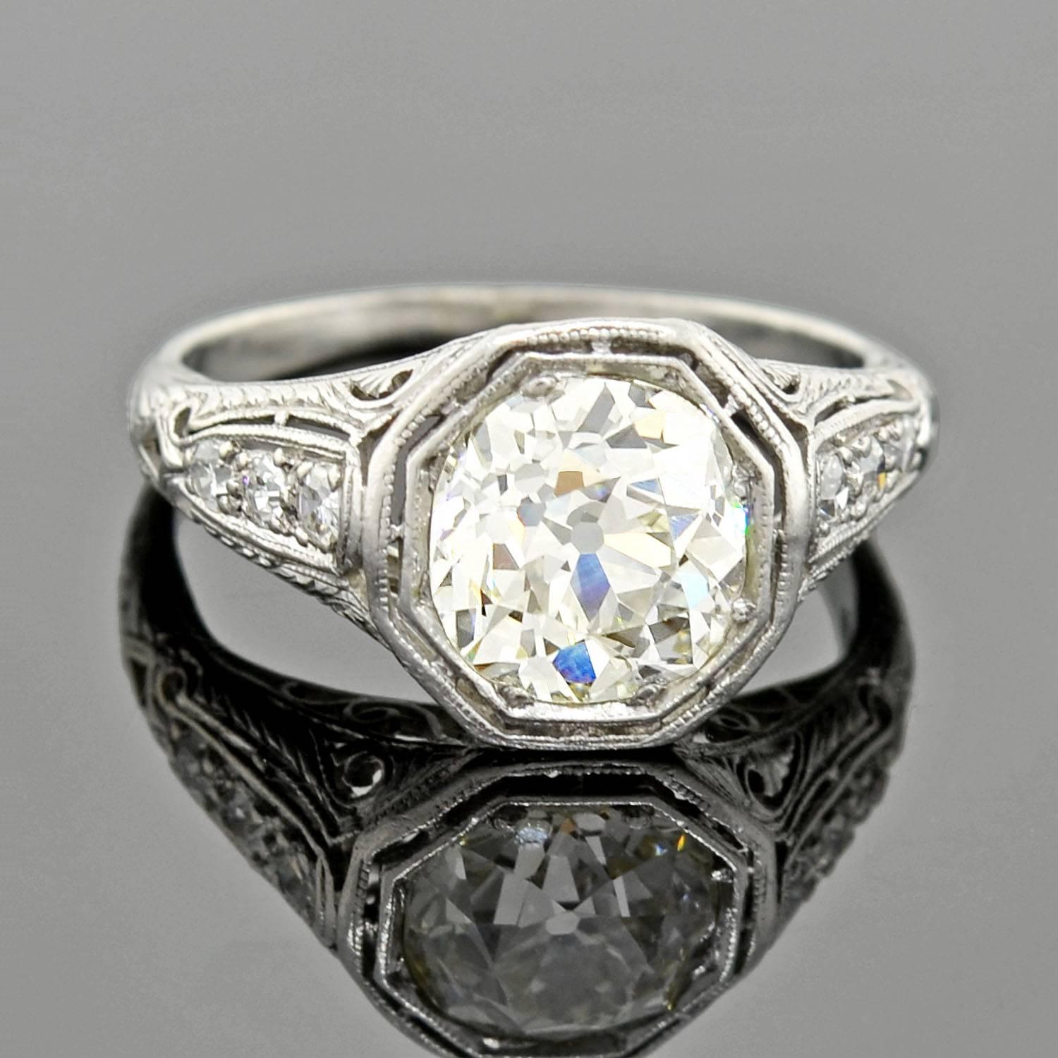 A simply spectacular diamond engagement ring from the Art Deco (ca1920) era! This outstanding ring is crafted in platinum and boasts an impressive and detailed design. At the center of the octagonal-shaped face is a sparkling old Mine Cut diamond,