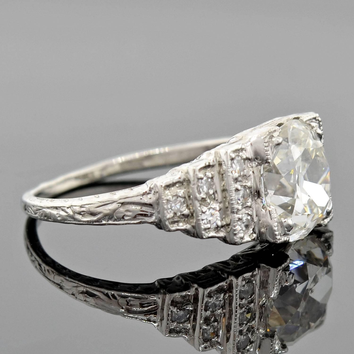 An exquisite diamond engagement ring from the Art Deco (ca1920) era! Made of platinum, this beautiful piece has a lovely "step-up" style mounting with three rows of diamonds on each shoulder and a gorgeous old European Cushion Cut diamond