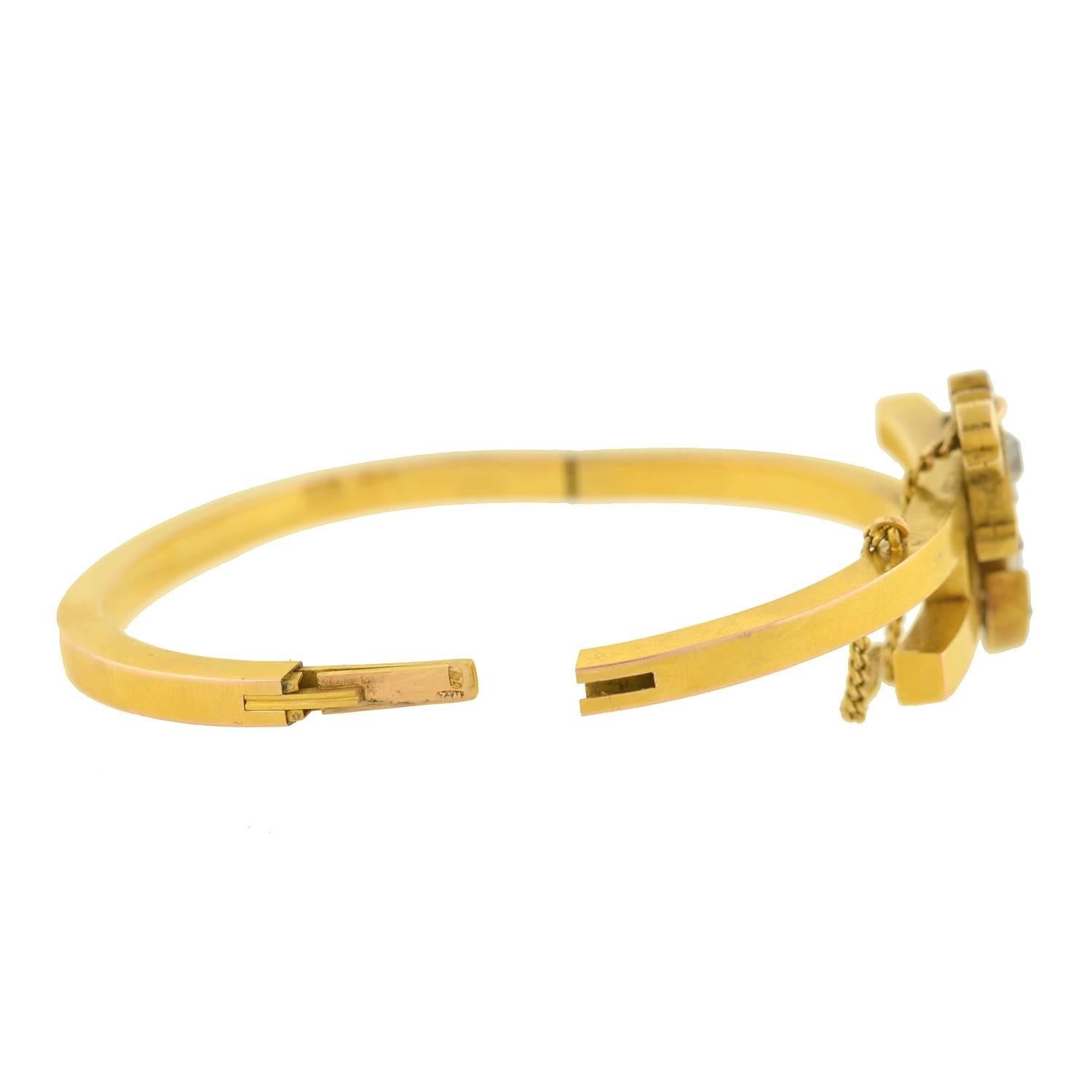 An incredible diamond anchor bracelet from the Victorian (ca1880) era! This beautiful bangle is crafted in 15kt gold (indicating English origin), and has a stylish bypass design that intersects at the front. Decorating the center is a stunning