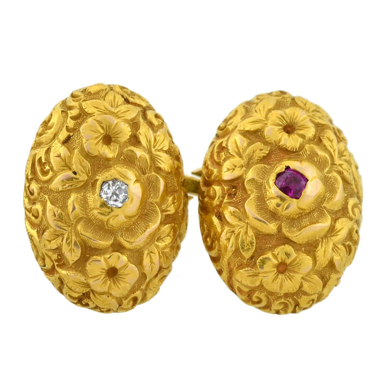 A beautiful pair of gemstone cufflinks from the Art Nouveau (ca1900) era! Crafted in vibrant 14kt gold, these double-sided cufflinks are bursting with detail. Each oval cufflink face is covered in textured repousse detail, forming a lovely floral