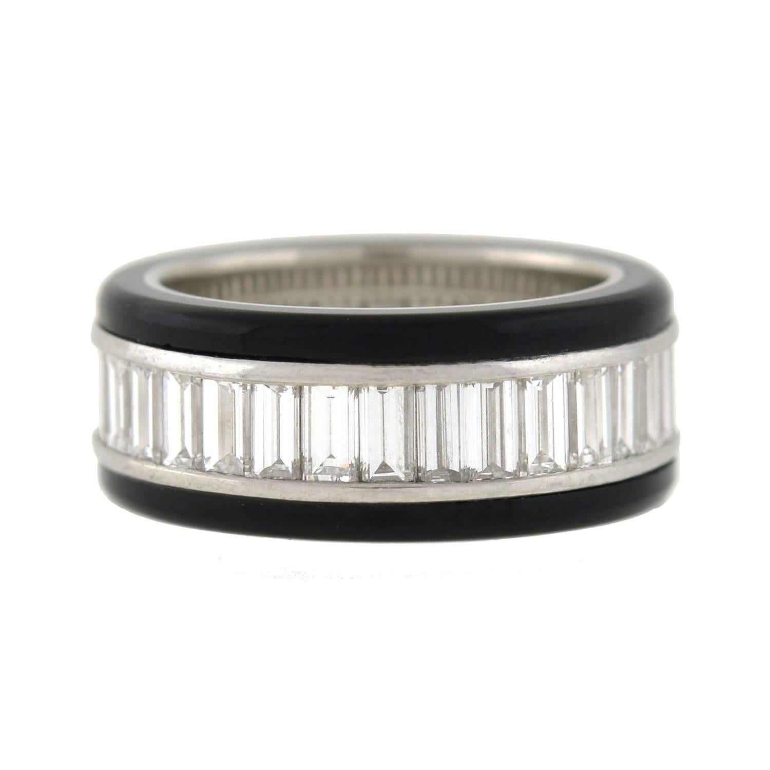 This outstanding estate ring is quite a beautiful and unusual piece! Crafted in platinum, the stylish design features a continuous row of baguette diamonds, which are framed by two bands of carved onyx on either side. The channel set diamonds weigh