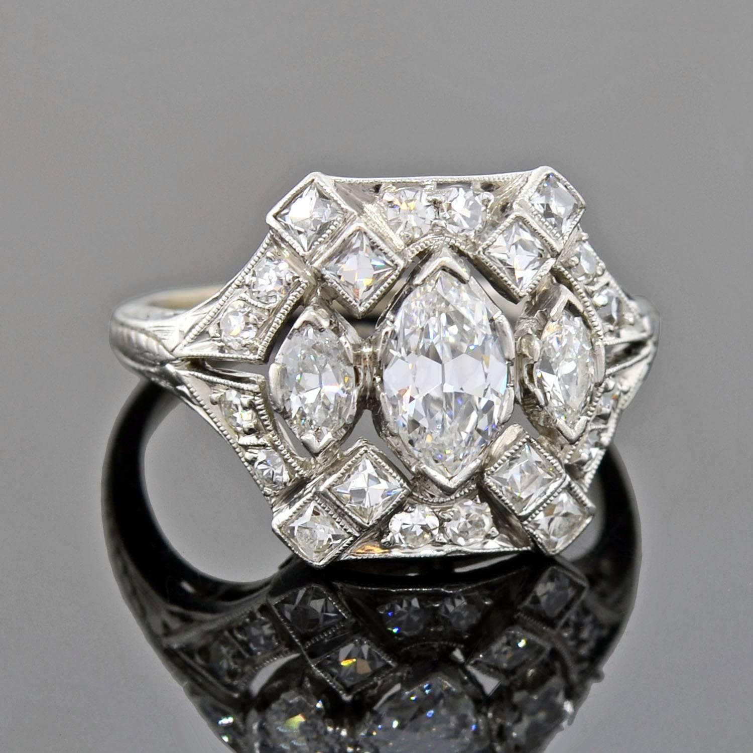 An exquisite diamond ring from the Edwardian (ca1910) era! Made of platinum, this gorgeous ring has an intricate filigree design that features a cluster of sparkling diamonds. Three marquise diamonds are set across the middle, surrounded by an