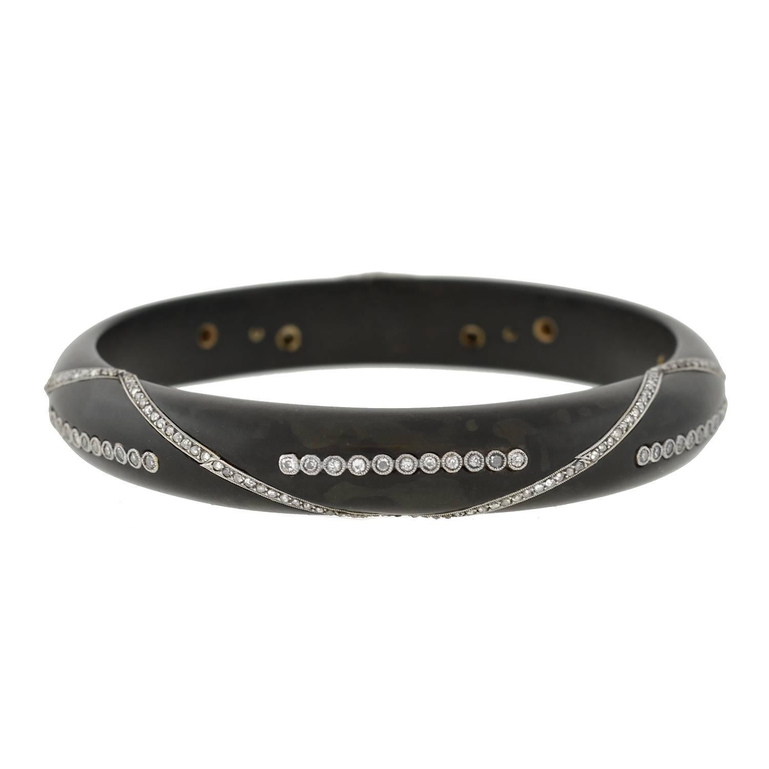 A very unusual bracelet from the Art Deco (ca1920) era! This stylish slip-on bangle is hand carved from ebony, which has a smooth, matte surface and rich black-brown color. Rows of delicate old single cut and rose cut diamonds decorate the surface