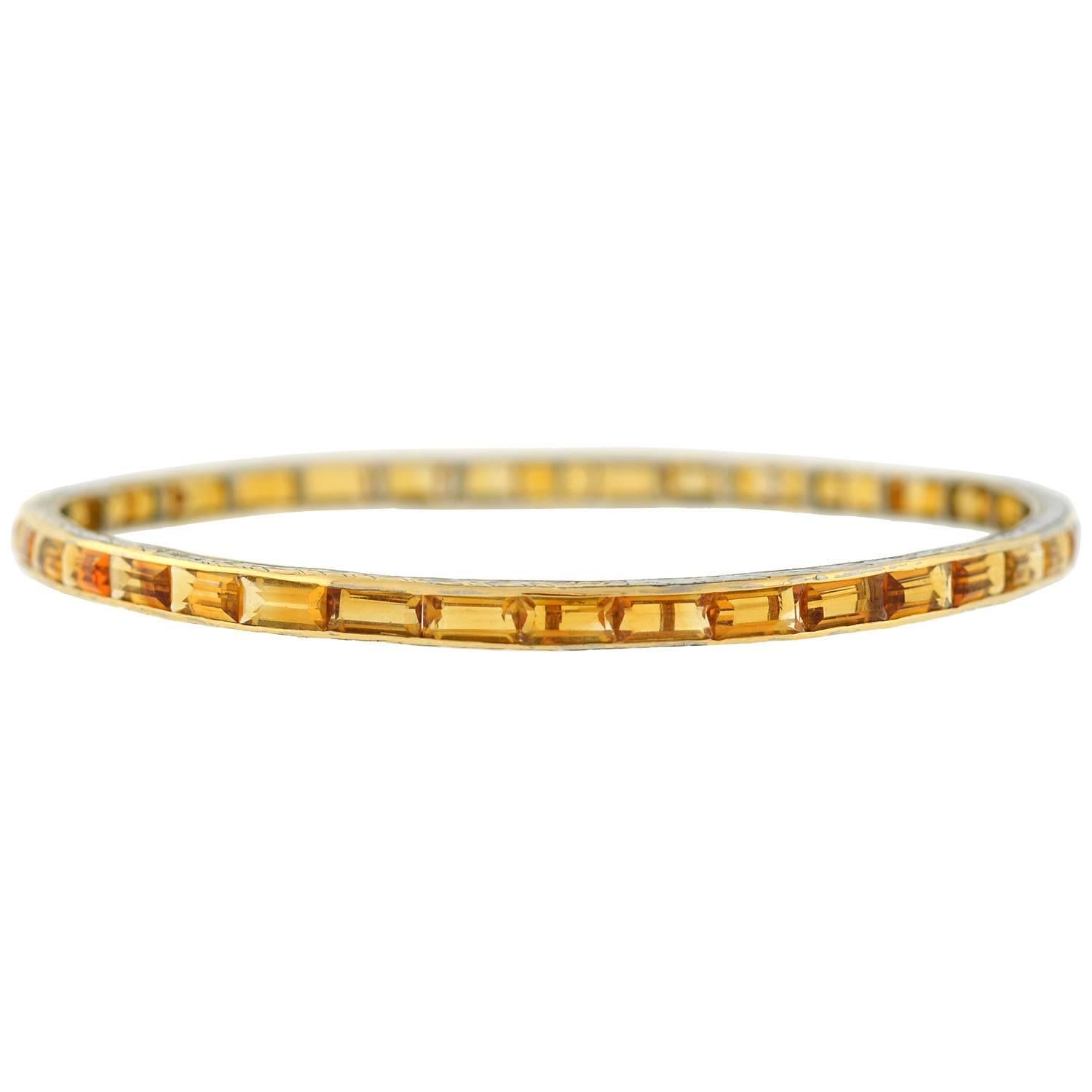 A beautiful citrine bracelet from the Art Deco (ca1920) era! This fabulous bangle bracelet is made of platinum-topped 14kt yellow gold, and is comprised of 38 channel set citrine stones. The rectangular step cut stones display a gorgeous rich golden