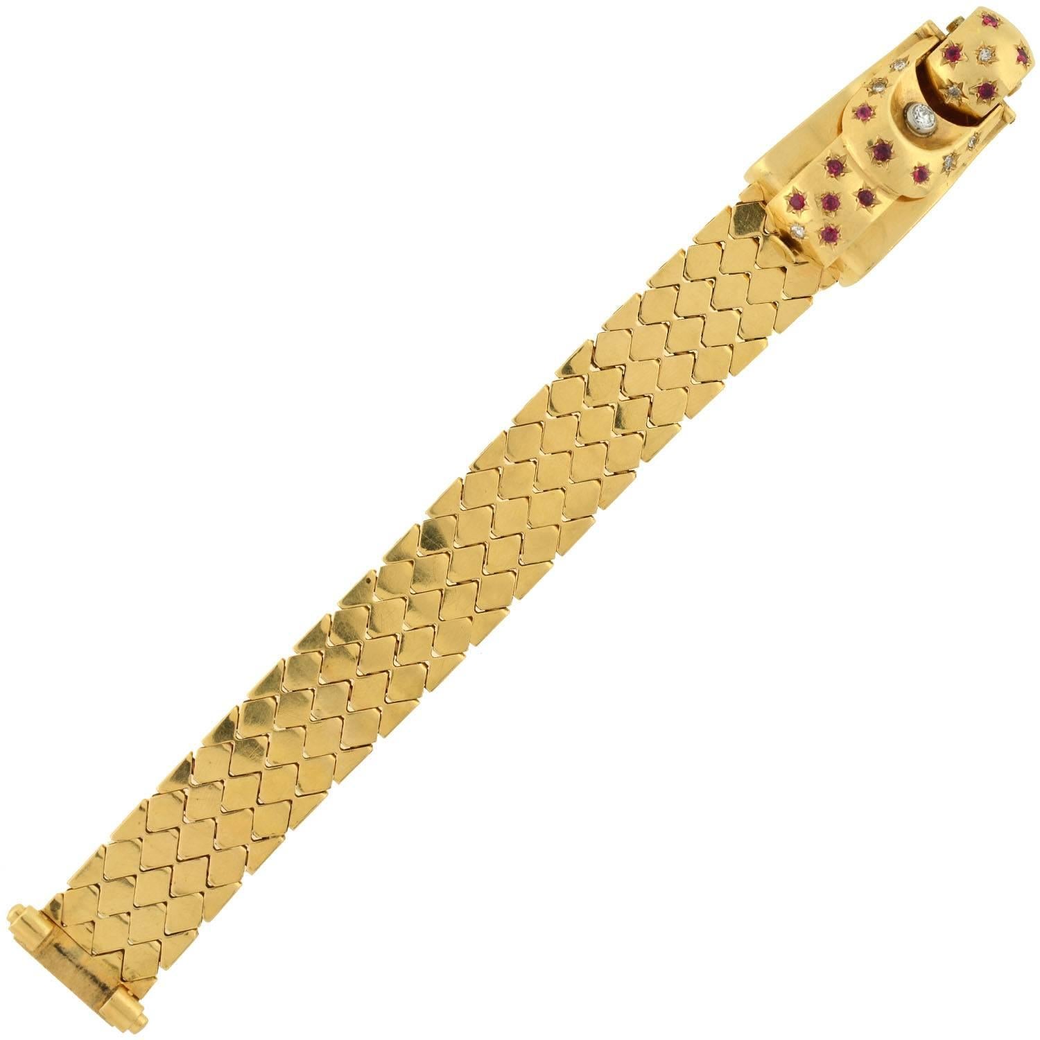 A fabulous gold, diamond and ruby buckle watch/bracelet from the Retro (ca1940) era! This wide, 3-dimensional looking watch is designed to look like a buckle and is made of 14kt yellow gold. The "strap" of the buckle is portrayed by a wide