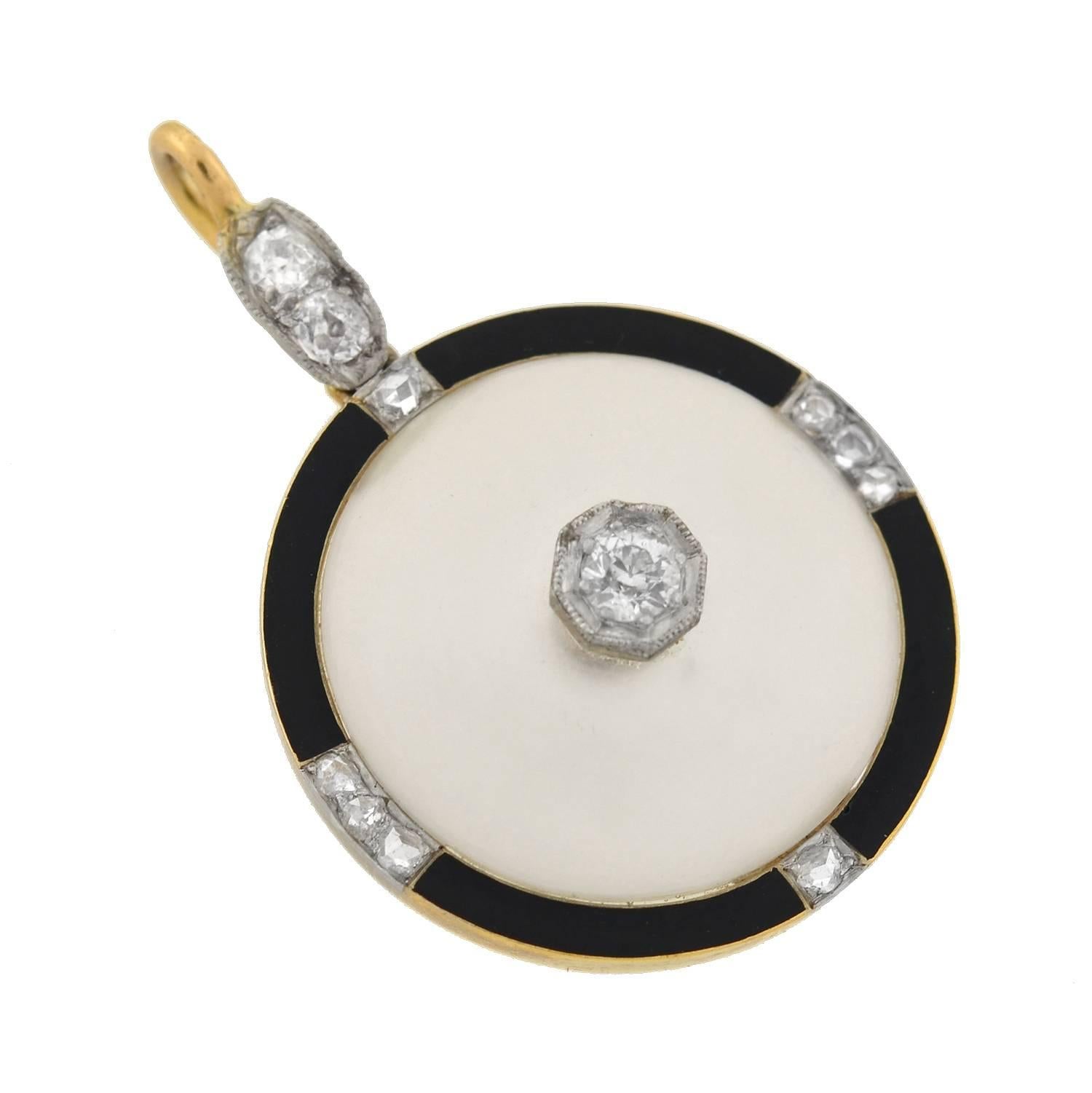 A very striking pendant from the Art Deco (ca1920) era! This beautiful pendant is crafted in 14kt gold with platinum accents. The piece is comprised of a frosted rock quartz crystal plaque, which rests within a circular bezel frame. Decorating the