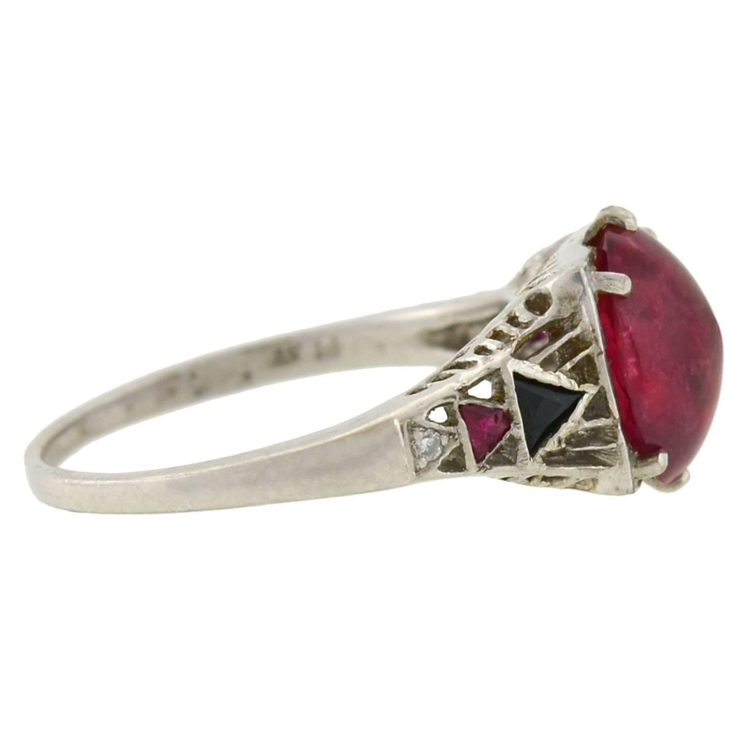 An unusual gemstone ring from the Art Deco (ca1920s) era! Crafted in platinum, this beautiful ring frames a 3.50ct natural no-heat Tanzanian ruby at the center of a filigree mounting. The gorgeous ruby is polished into a smooth oval shape,