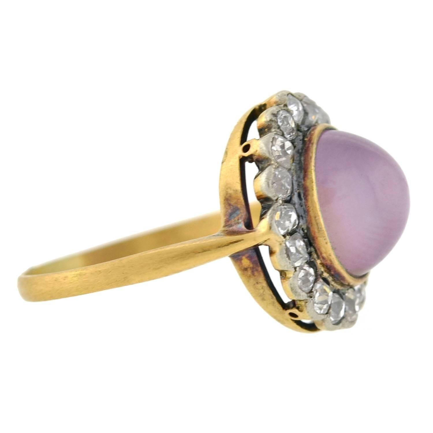 A beautiful lavender star sapphire ring from the Victorian (ca1880) era! Crafted in 18kt gold and sterling silver, this gorgeous ring holds a luscious 4.50ct lavender star sapphire cabochon at the center. When turned in the light, the stone reveals