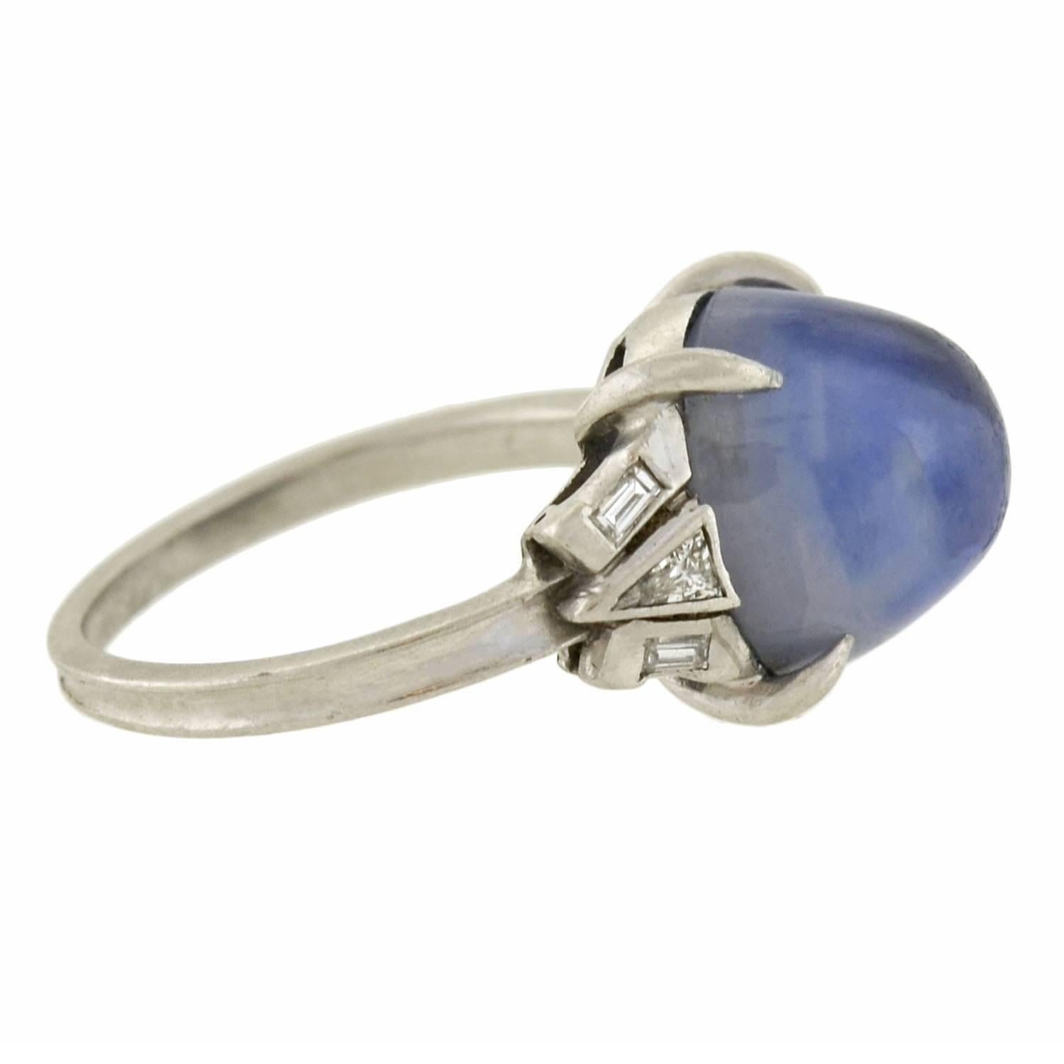 A simply stunning sapphire and diamond ring from the late Art Deco (ca1930) era! This fantastic platinum piece adorns an incredible natural star sapphire cabochon at the center of a gorgeous setting. The stone weighs approximately 4.50ctw and