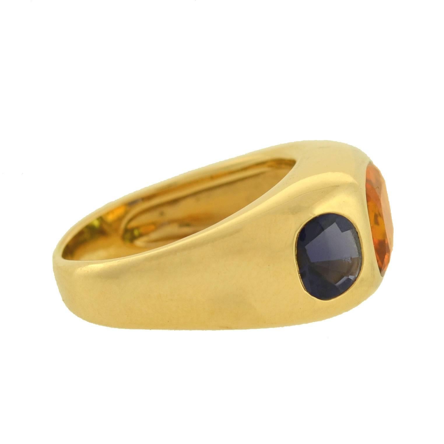 A fabulous 3-stone ring by legendary fashion house Chanel! This stunning and unusual ring is crafted in 18kt yellow gold and adorns three vibrant gemstones: a citrine in the center, and a peridot and iolite on the sides. The citrine is larger than