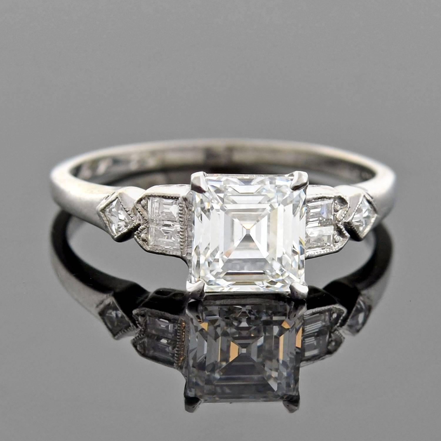 A beautiful diamond engagement ring from the Retro (ca1943) era! This gorgeous platinum ring holds a Square Emerald Cut diamond at the center of a lovely setting. The prong-set diamond weighs 1.39ct, and has F color and VS1 clarity. Set on the