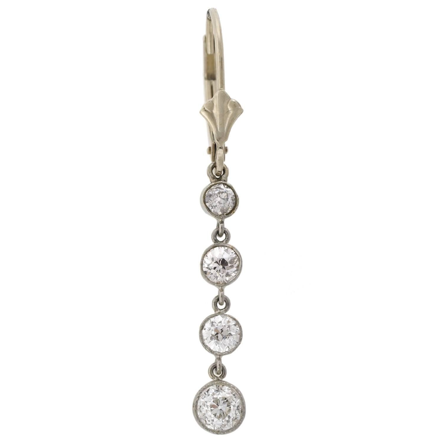 A dazzling pair of diamond earrings from the Edwardian (ca1910) era! These elegant earrings are made of platinum and hang from modern 14kt white gold lever back wires. Each earrings displays a simple, yet beautiful design. Four sparkling old