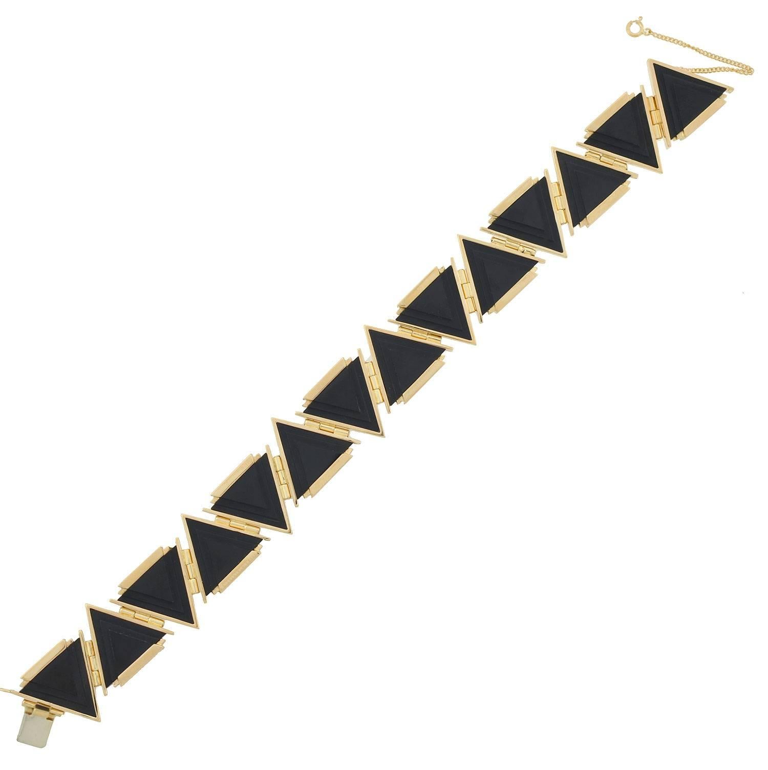 A fabulous and unusual onyx link bracelet from the late Art Deco (circa 1930s) era! This gorgeous piece features 14 triangular shaped onyx stones which are set in 14kt rose gold. The onyx stones have a carved surface with an attractive 3-step tiered
