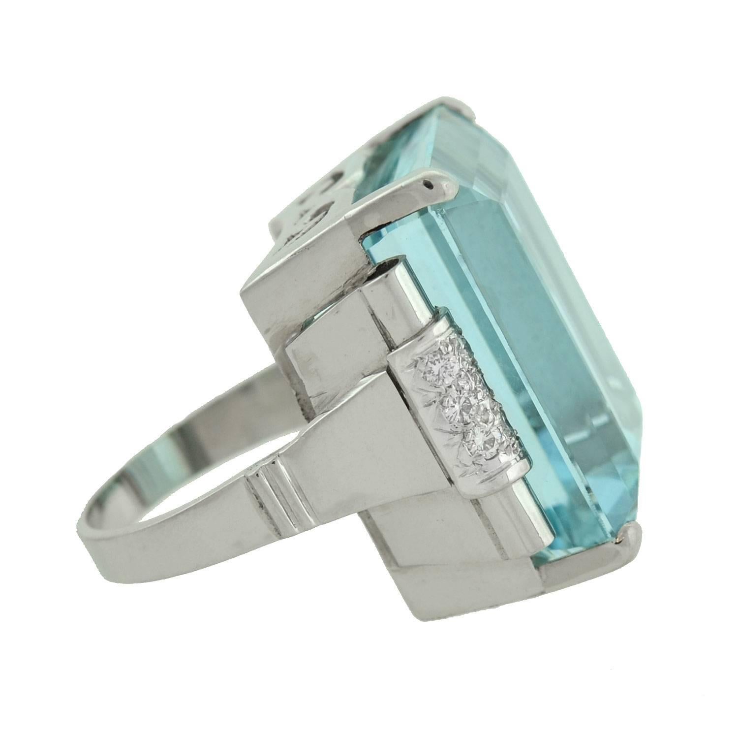 A simply stunning aquamarine cocktail ring from the Retro (ca1940) era! This fabulous piece is made of platinum and holds a large Emerald Cut aquamarine stone at its center. The aqua, which is prong set, has a total approximate weight of 33 carats