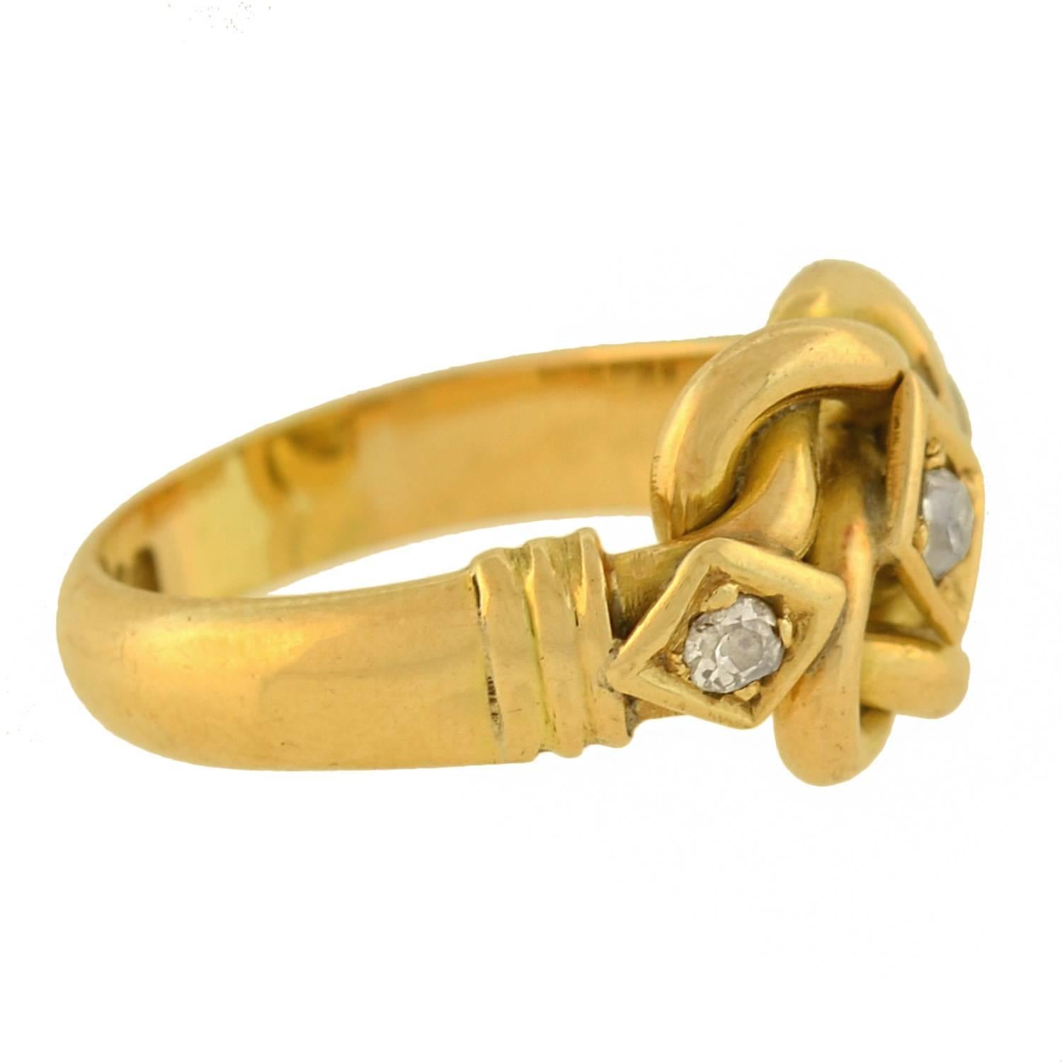 An absolutely stunning ring from the Edwardian (ca1911) era! This gorgeous piece is made of 18kt yellow gold and comprised of two gold tubes that twist and intertwine, forming the shape of an attractive love knot. Set within the center of the knot