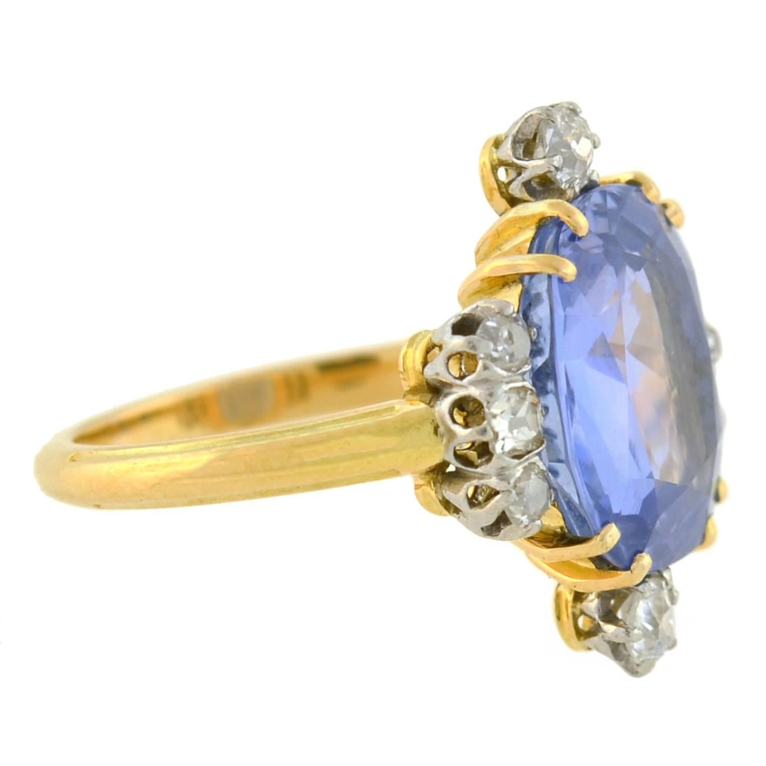 An exquisite sapphire ring from the Edwardian (ca1910s) era! Made of 18kt yellow gold, the ring holds a stunning natural, no heat sapphire at the center, framed by sparkling diamonds on all four sides. The Ceylon (Sri Lankan) sapphire weighs 6.80ct,