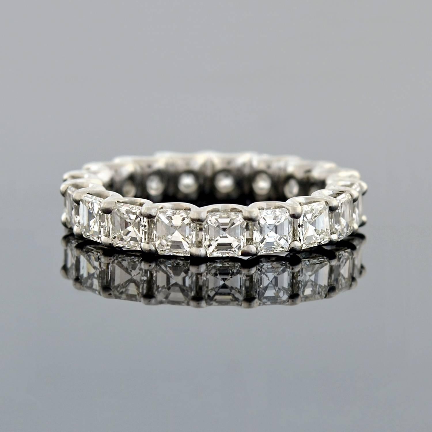 This estate diamond eternity band is quite spectacular! Made of platinum, the ring features a row of 19 outstanding Asscher Cut diamonds, which carry seamlessly around the surface in a shared prong setting. The sparkling stones have H-I range color,