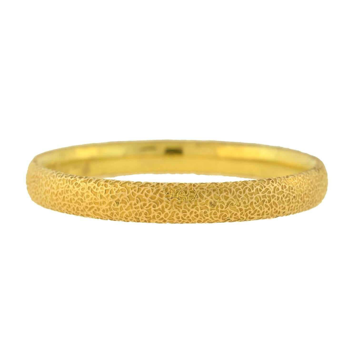 A stunning and unique bangle bracelet from the Art Nouveau (ca1906) era! Crafted in 14kt yellow gold, the entire surface of the piece is decorated with a fine applied wirework pattern. The design creates an intricate texture that reflects the light