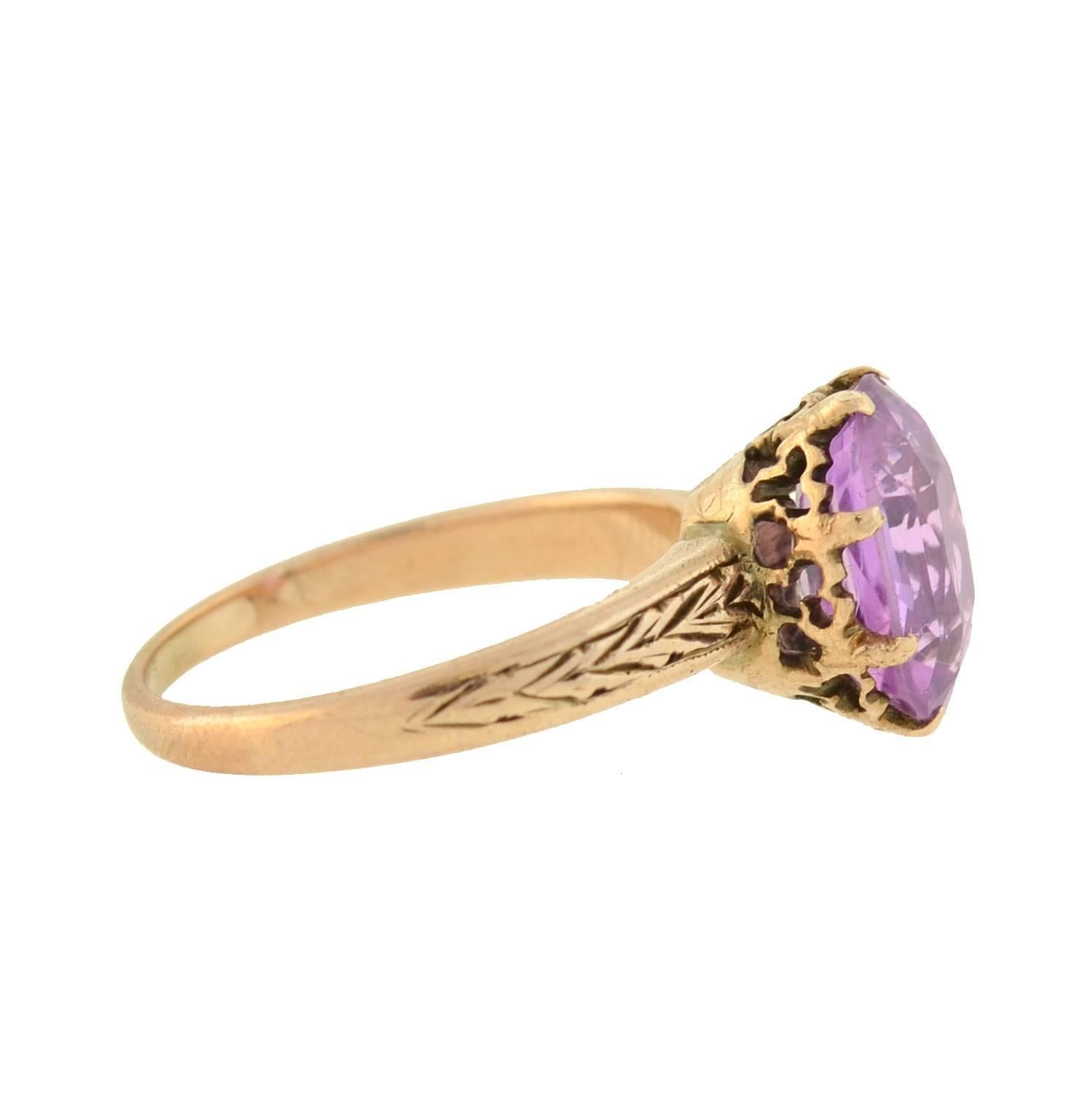 A fantastic pinkish purple sapphire ring from the Victorian (ca1880) era! Beautiful in its simplicity, this solitaire-style ring is crafted in 14kt rosy yellow gold and features a natural pinkish purple sapphire at the center. The stone, which rests
