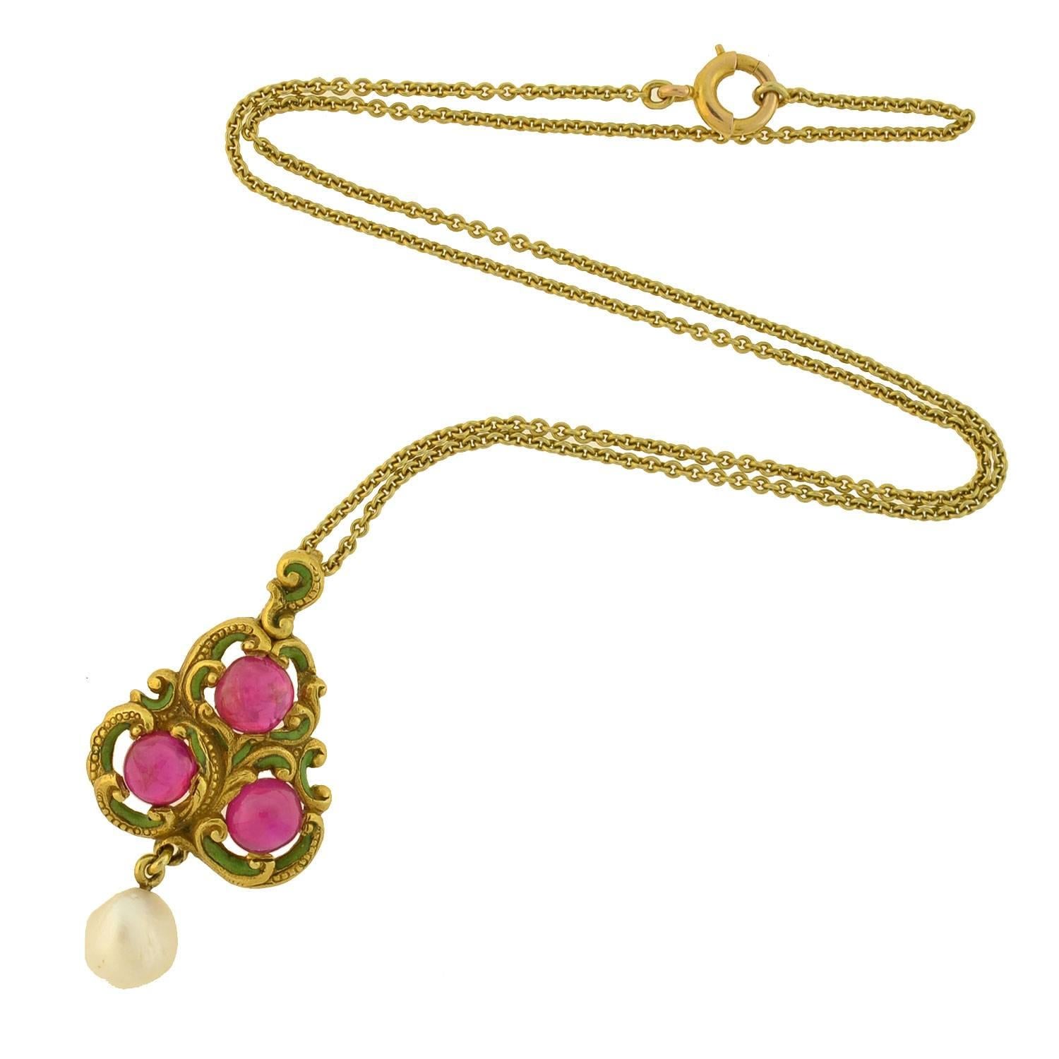 A beautiful and delicate natural ruby pendant from the Art Nouveau (ca1910) era! Made of 18kt yellow gold, this exquisite piece features three luscious Burmese ruby cabochons that form the shape of a flowing triangular pendant. Each ruby has an open
