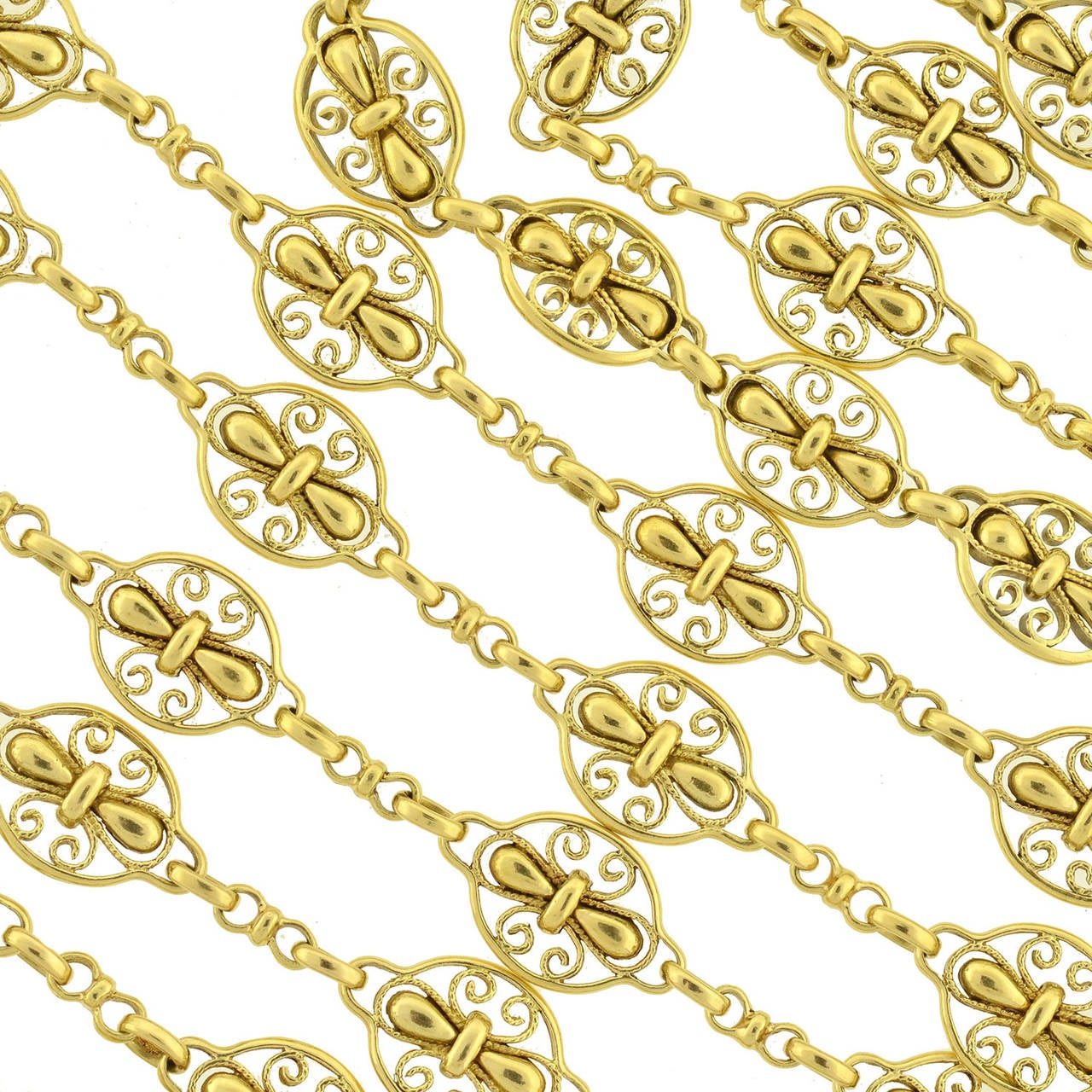 This stunning gold chain from the Art Nouveau (ca1900) era is quite a special piece! Substantial in both length and weight, this fancy chain is comprised of vibrant 18kt yellow gold links, which have a beautiful filigree Fleur de Lys design. Each