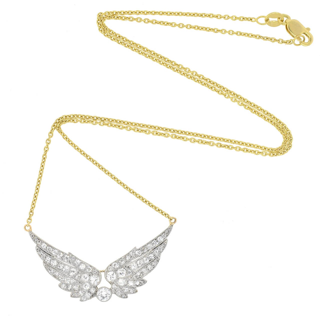 An absolutely stunning diamond wing necklace from the Edwardian (ca1910) era! This spectacular piece is comprised of a dazzling pendant that hangs from a fine gold cable chain. The pendant is made of platinum-topped 14kt yellow gold and depicts a