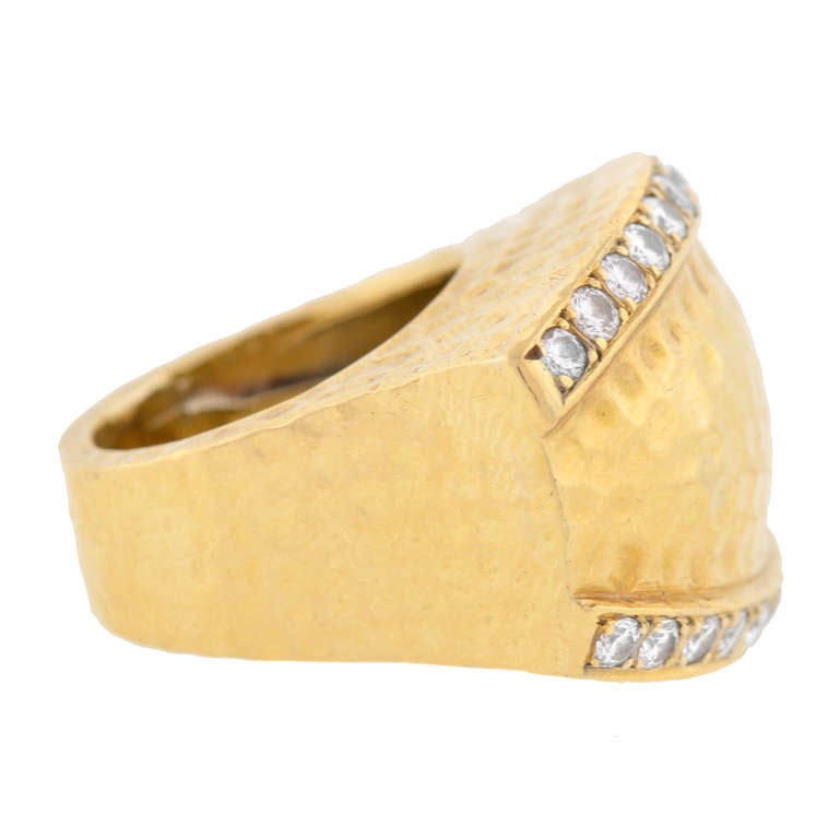 This fabulous Estate ring has a striking look and a bold, fashionable look! Made of vibrant 18kt yellow gold, the piece is very substantial in size and has a striking contemporary design. The face of the ring has a curved rectangular shape and
