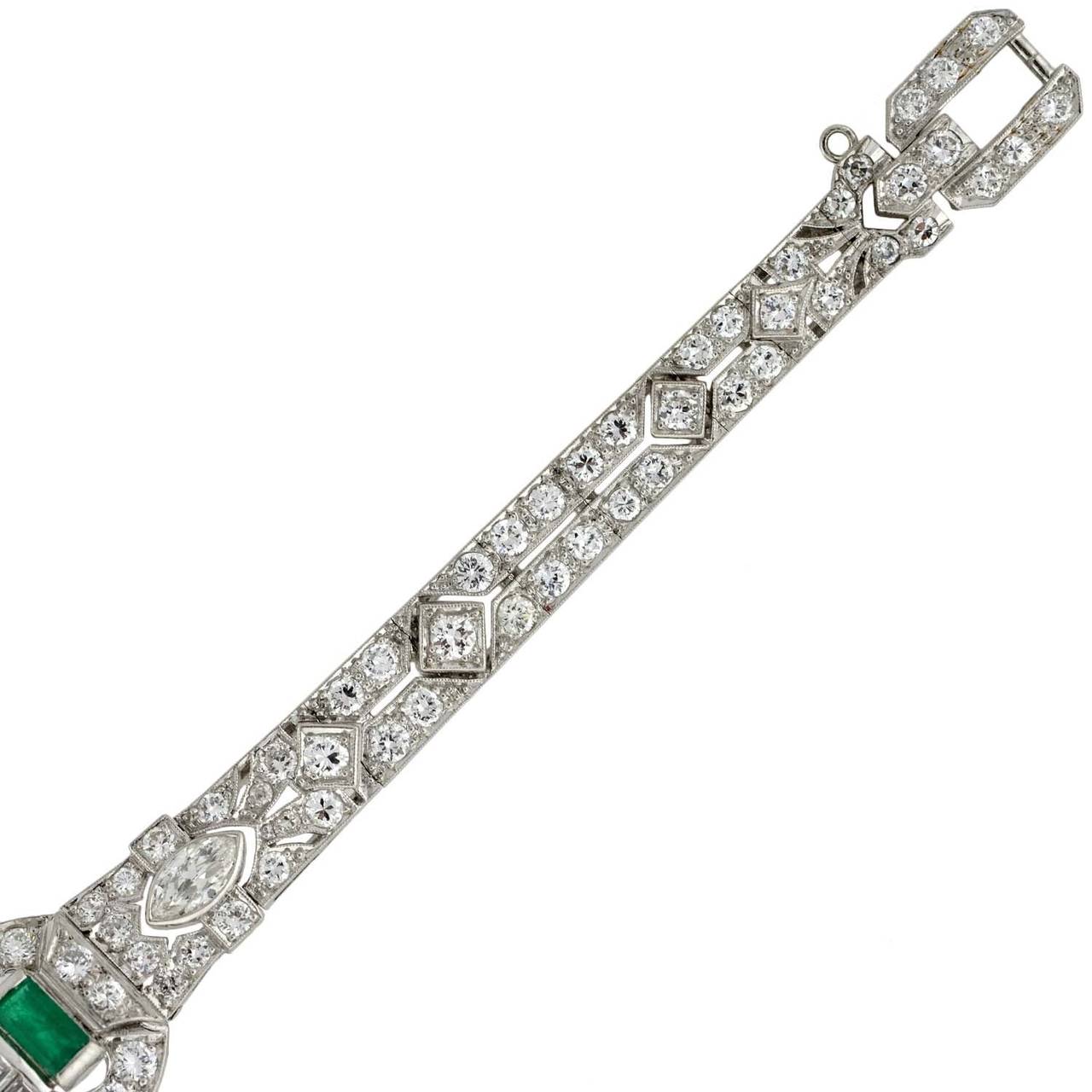 An absolutely exquisite diamond and emerald encrusted bracelet from the late Art Deco (ca1930) era! This luxurious piece is made of platinum and features over 6.00 carats of diamonds and 3 luscious emeralds. The belly front line bracelet is