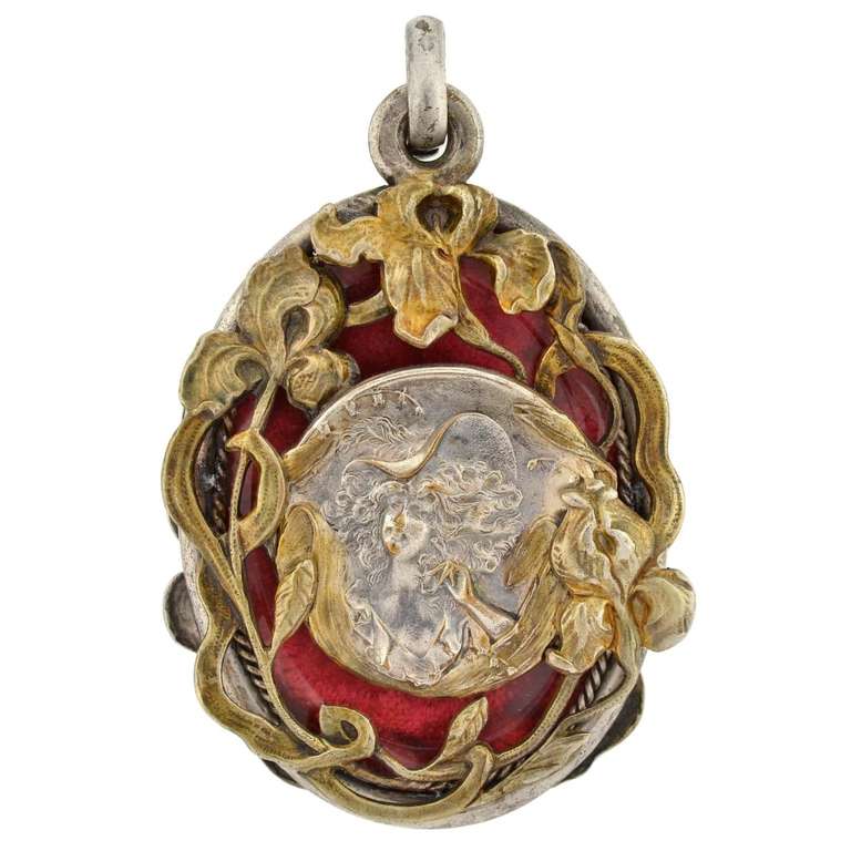 An extraordinary slide locket from the Art Nouveau (ca1900) era! This lovely piece is made of gilded sterling and has the wonderful repousse image of a beautiful woman's face on each side. The oval-shaped locket is particularly large in size and has