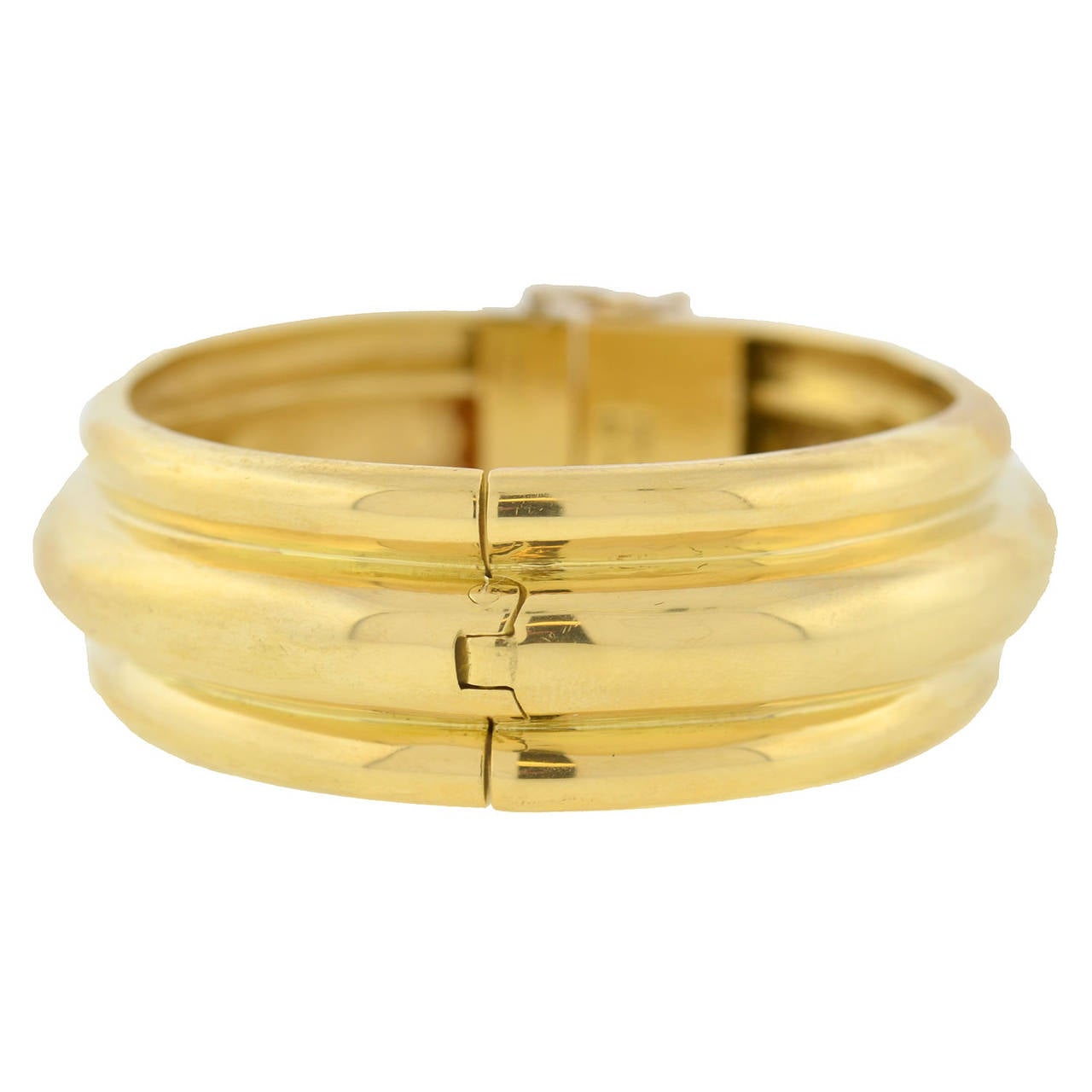 A fabulous yellow gold Estate bangle bracelet! This gorgeous piece is made of vibrant 18kt yellow gold and features an attractive grooved design that runs all the way around the piece with a raised gold area in the center. The bracelet is hinged and