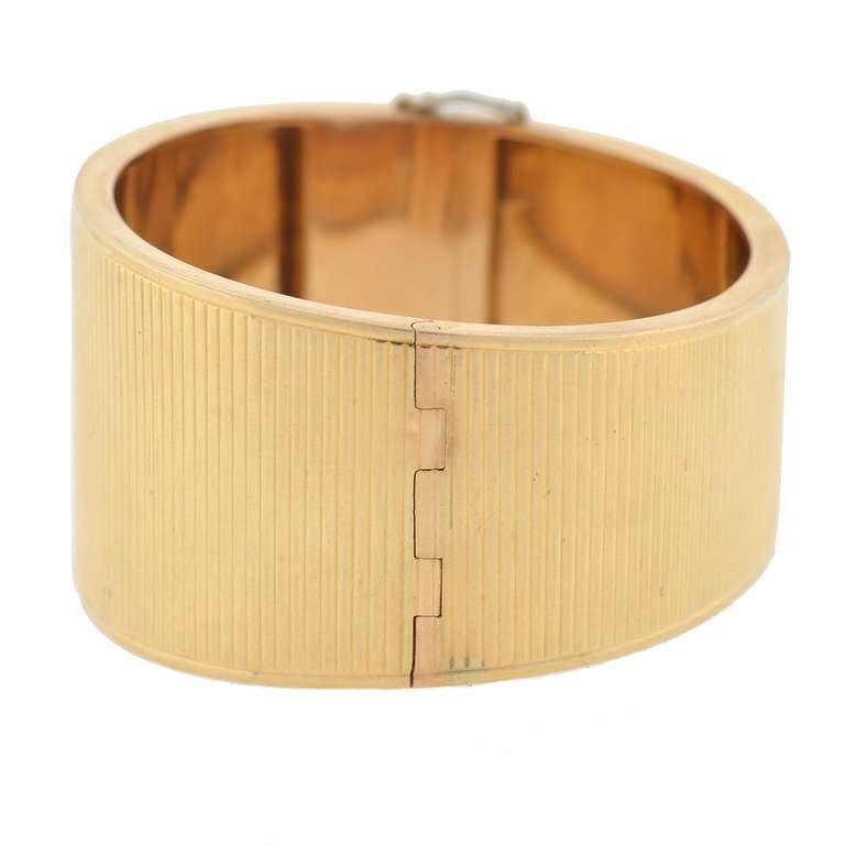 An absolutely fabulous gold bangle bracelet from the Retro (ca1940s) period! Made of vibrant 14kt yellow gold, this attractive piece has a very versatile and wearable design. The bracelet is fairly wide, with a textured surface comprised of a
