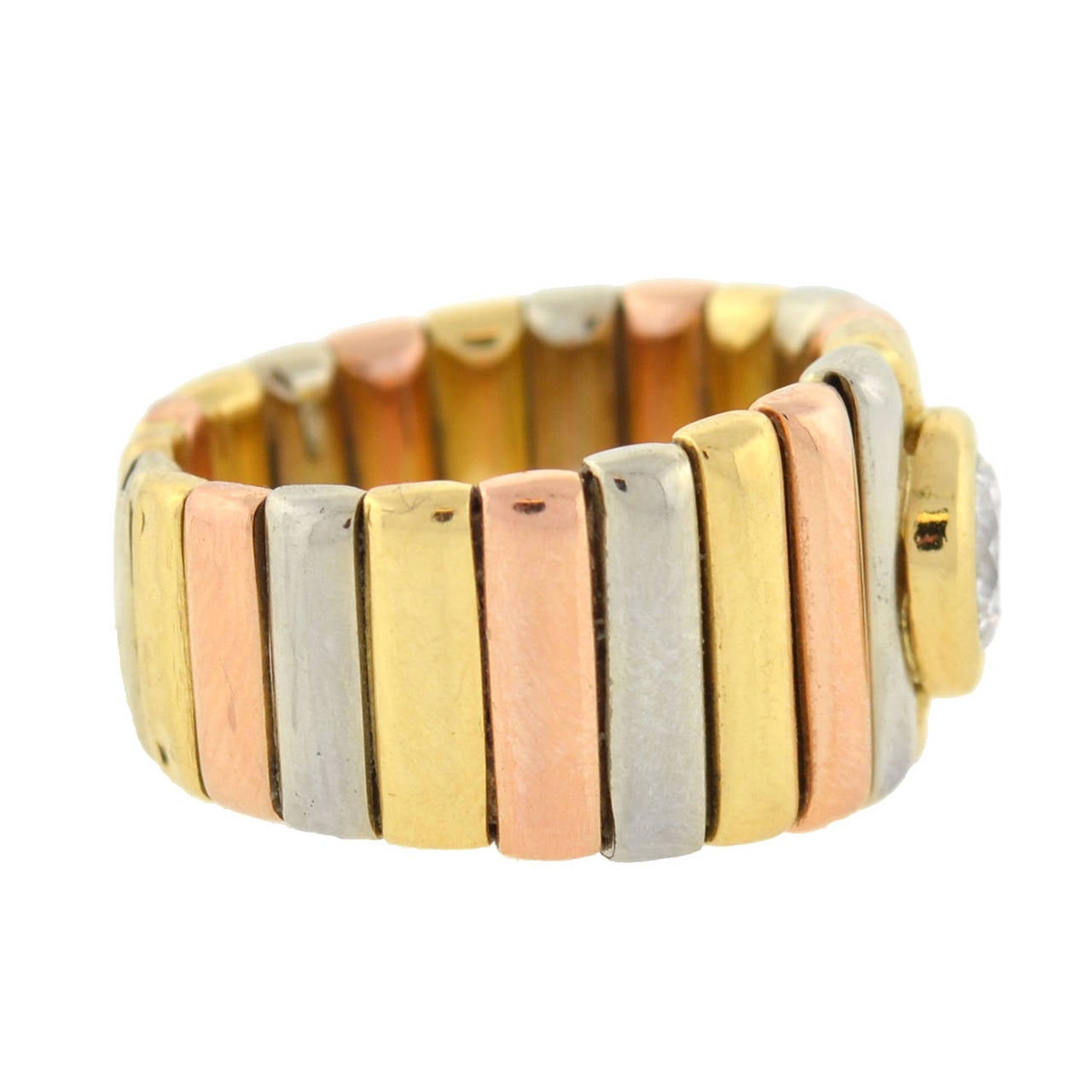 This fabulous Estate ring is a signed piece by Cartier! Made of vibrant 18kt yellow gold, the heavy, wide ring has a striking tri-color design and is substantial in size. A pattern of yellow, rose, and white gold bars form the band, giving the