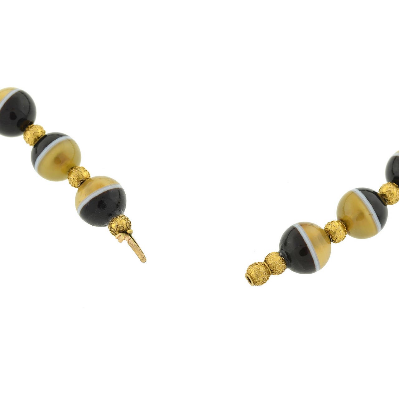 A rare honey banded agate necklace from the Victorian (ca1880) era! A strand of honey banded agate beads alternates with vibrant 18kt yellow gold Etruscan bead spacers to form this beautiful necklace. All of the honey banded agate beads are smoothly
