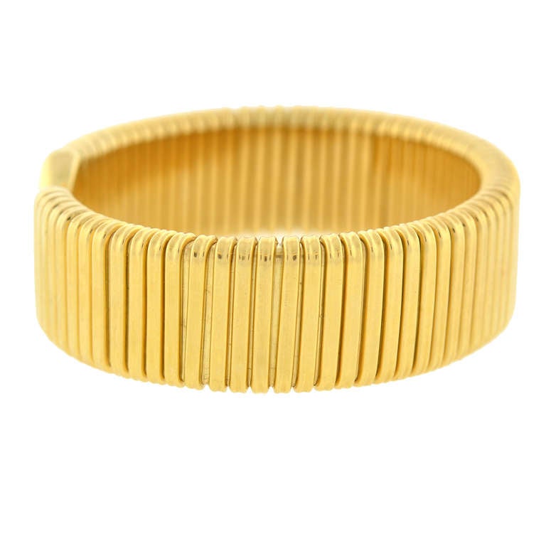 A fabulous Vintage gooseneck bracelet from the 1970s! This striking cuff-style bracelet is made of vibrant 18kt yellow gold, and has a ridged gooseneck design that carries along both sides of the piece. Each end of the bracelet is flexible and can
