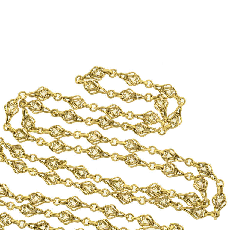 A gorgeous French chain from the Art Nouveau (circa 1900) era! Extremely long in length, this fancy chain is comprised of vibrant 18kt gold links, which have a beautiful and ornate design. Each delicate filigree wirework link alternates with small