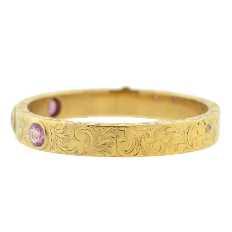 A stunning bangle bracelet from the Victorian (circa 1880) period! This gorgeous piece is made of 14kt yellow gold and holds 3 genuine sapphire stones set across the front. The bezel-set sapphires are varied in size and color, exhibiting a range of