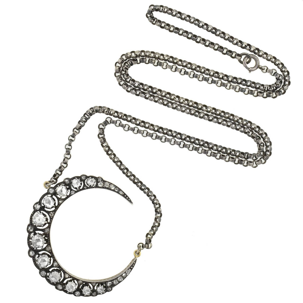 A magnificent diamond crescent necklace from the Victorian era (ca1880)! Made of sterling-topped 15kt gold, the necklace is comprised of a dazzling crescent moon pendant that hangs from a long sterling chain. The crescent is lined with beautiful